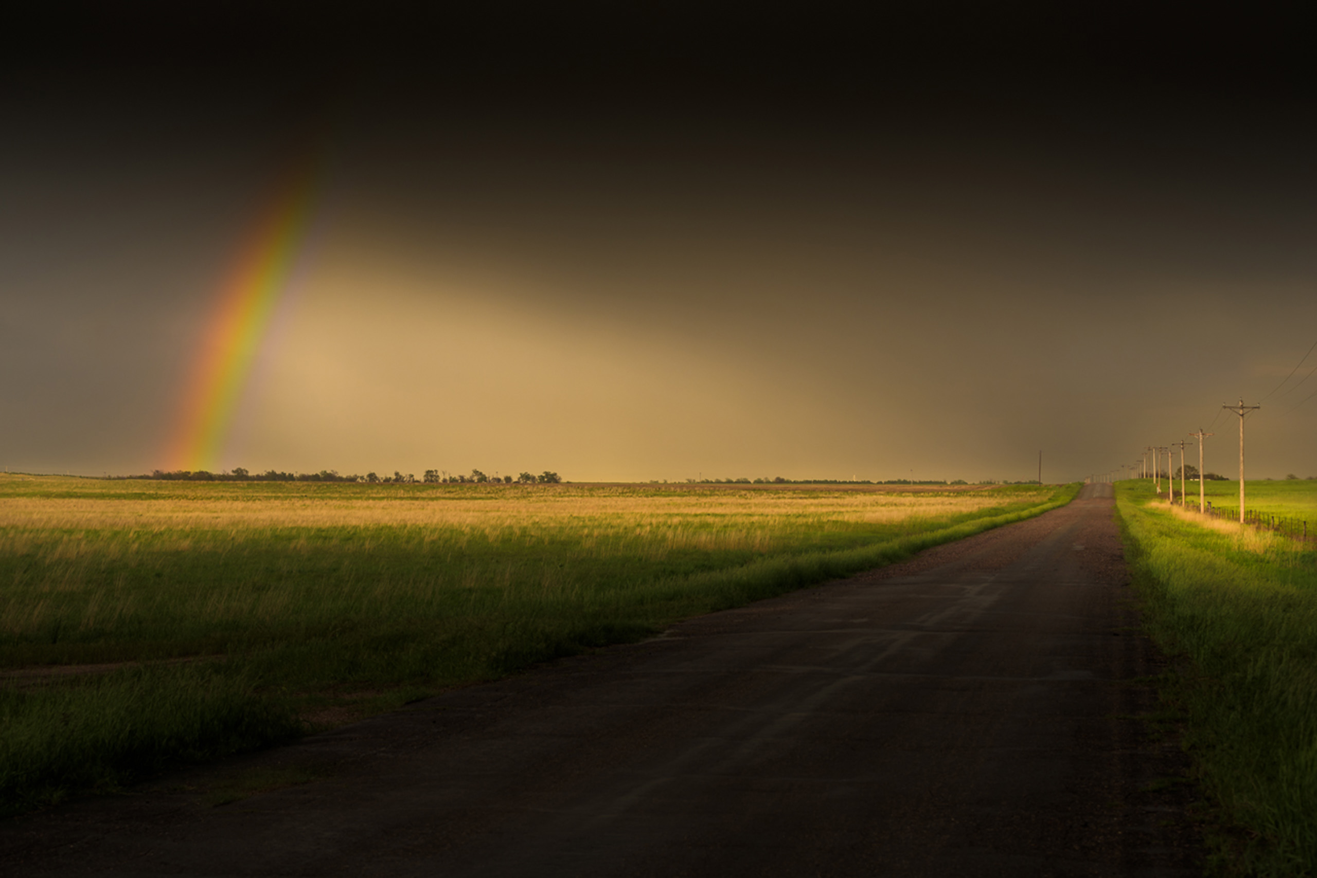 A rainbow appears near Bridgeport, Nebraska, as a storm dies in the soft light just before sunset.