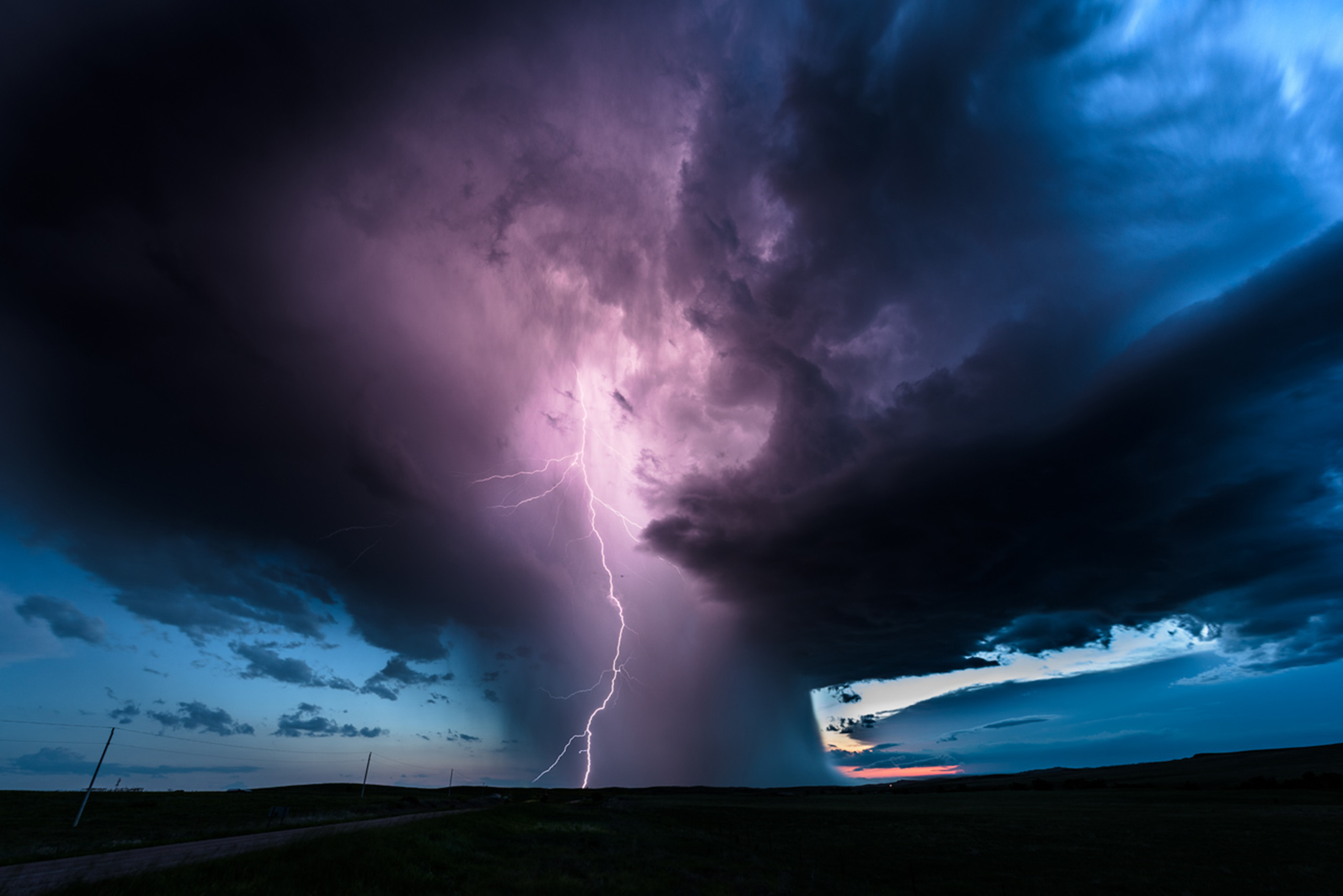 lightning illuminates a massive shaft of rain and hail near the Badlands in western South Dakota.