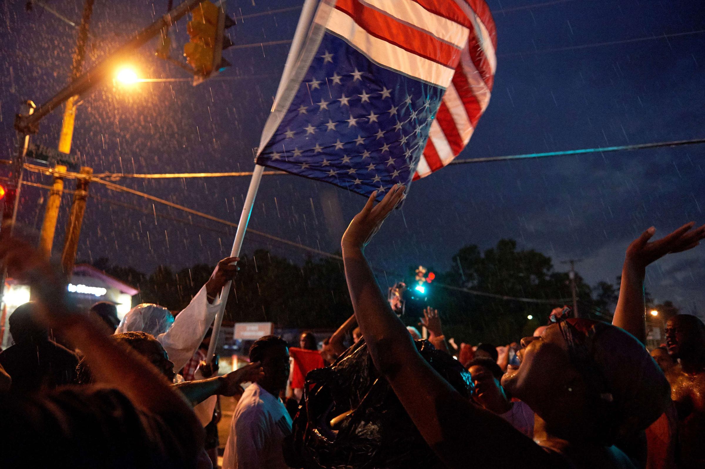 TOPSHOTS Demonstrators participate in a protest march on West Florissant Avenue in Ferguson, Missouri on August 9, 2015. A day of peaceful remembrance marking the anniversary of 18-year-old black teen Michael Brown's killing by police in the US city of Ferguson came to a violent end on August 9 as gunfire left at least one protester injured. AFP PHOTO / MICHAEL B. THOMASMichael B. Thomas/AFP/Getty Images