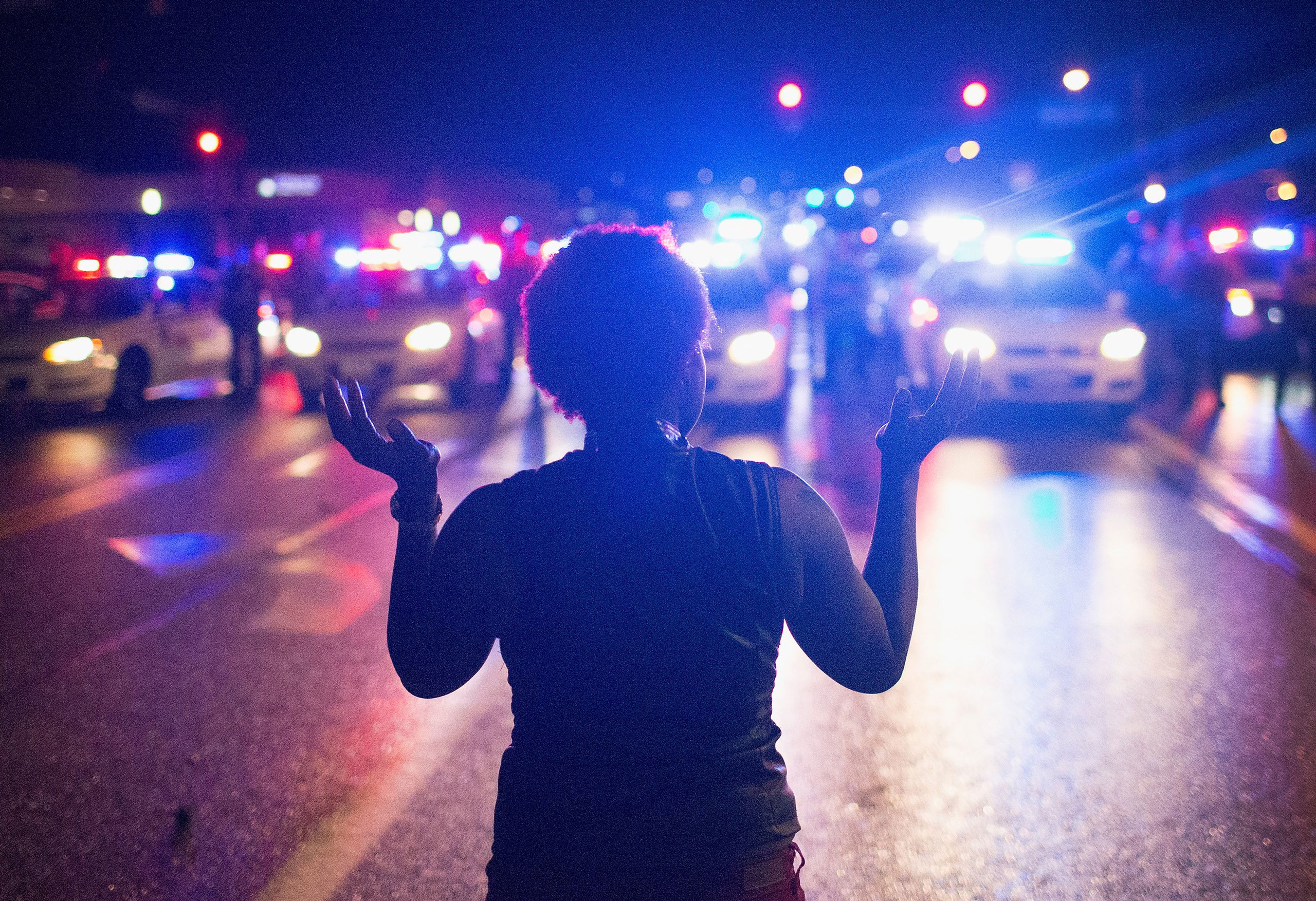 Demonstrators, marking the one-year anniversary of the shooting of Michael Brown, face off with police during a protest along West Florrisant Street in Ferguson, Mo., on August 9, 2015.