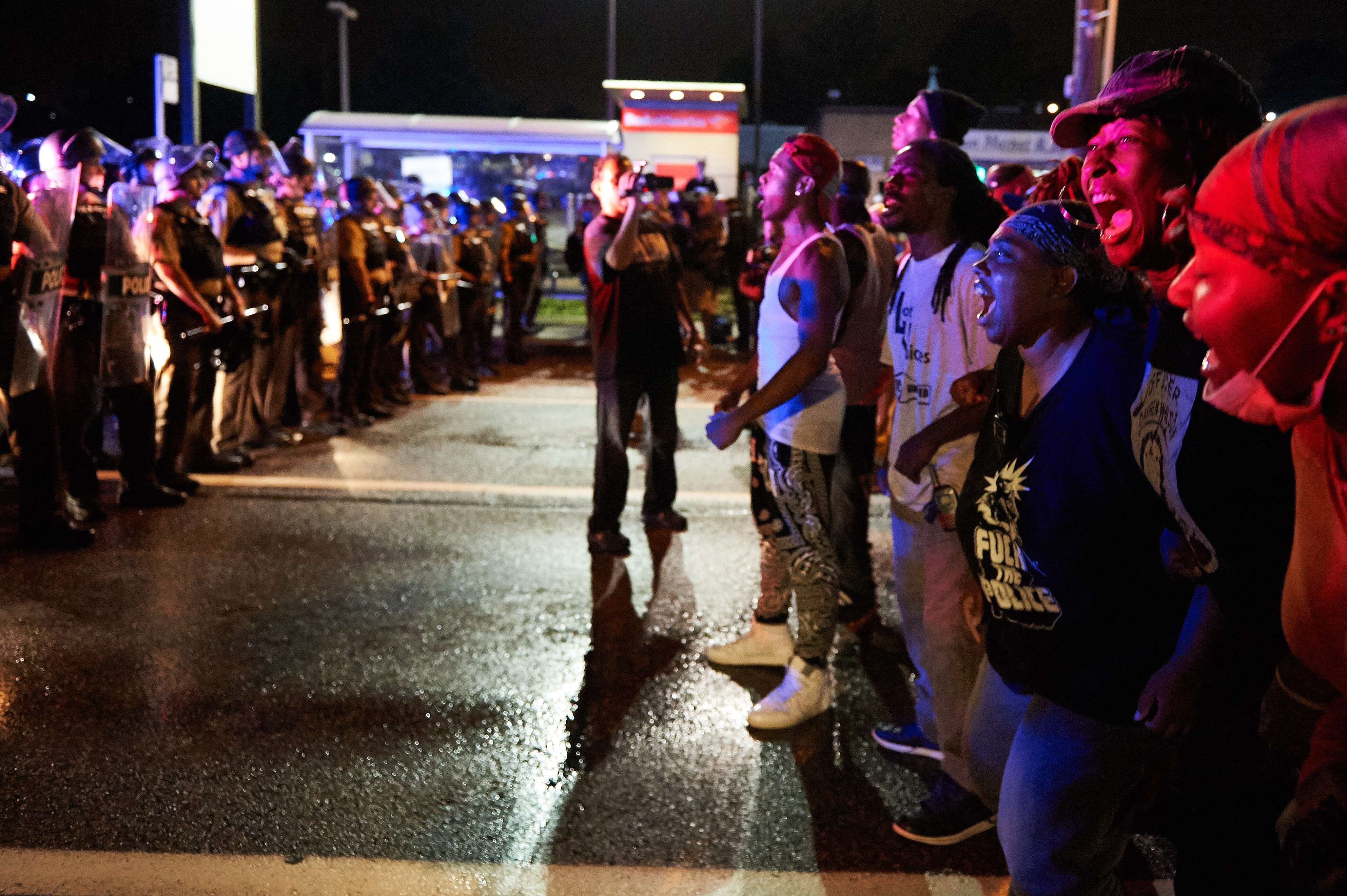 A group of demonstrators yell in front of police officers during a protest march on West Florissant Avenue in Ferguson, Mo. on August 9, 2015. (Michael B. Thomas—AFP/Getty Images)