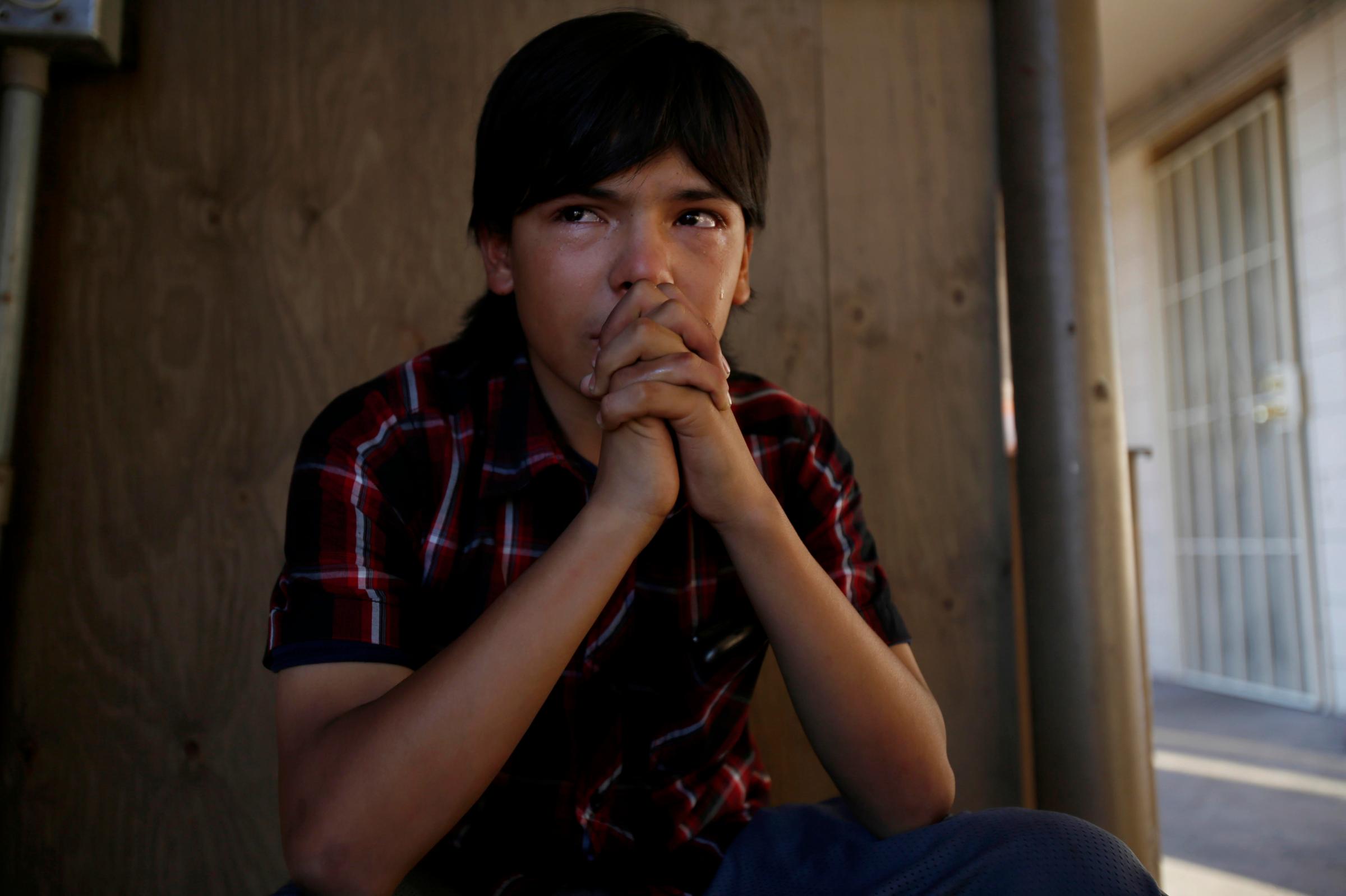 FEBRUARY 11, 2015:  In tears, Eddie Martinez, 14, sits under the stairwell crying at the  Country Inn, in San Bernardino, CA, February 11, 2015. He is trying to help his friend Breanna. Eddie mother Noreen Gutierrez is in jail, and he wonders between a near by apartment, and the motel. He stuffed two sheets of notebook paper into his backpack. He had written, "I’m losing everything in my life for good the only thing I haven’t lost yet is my life but I hope I’ll lose it soon cause I can’t take it anymore." That night he was sitting outside around 11 pm, when the police pulled up, below Breanna’s room. Social workers followed. Breanna, her siblings, along with Eddie,  were taken into social services. Eddie's is now with his father.  “I Wonder if anyone would miss me when I’m Gone,” Eddie later posted on Facebook. He got three “likes” but no comments.  (Francine Orr/ Los Angeles Times)