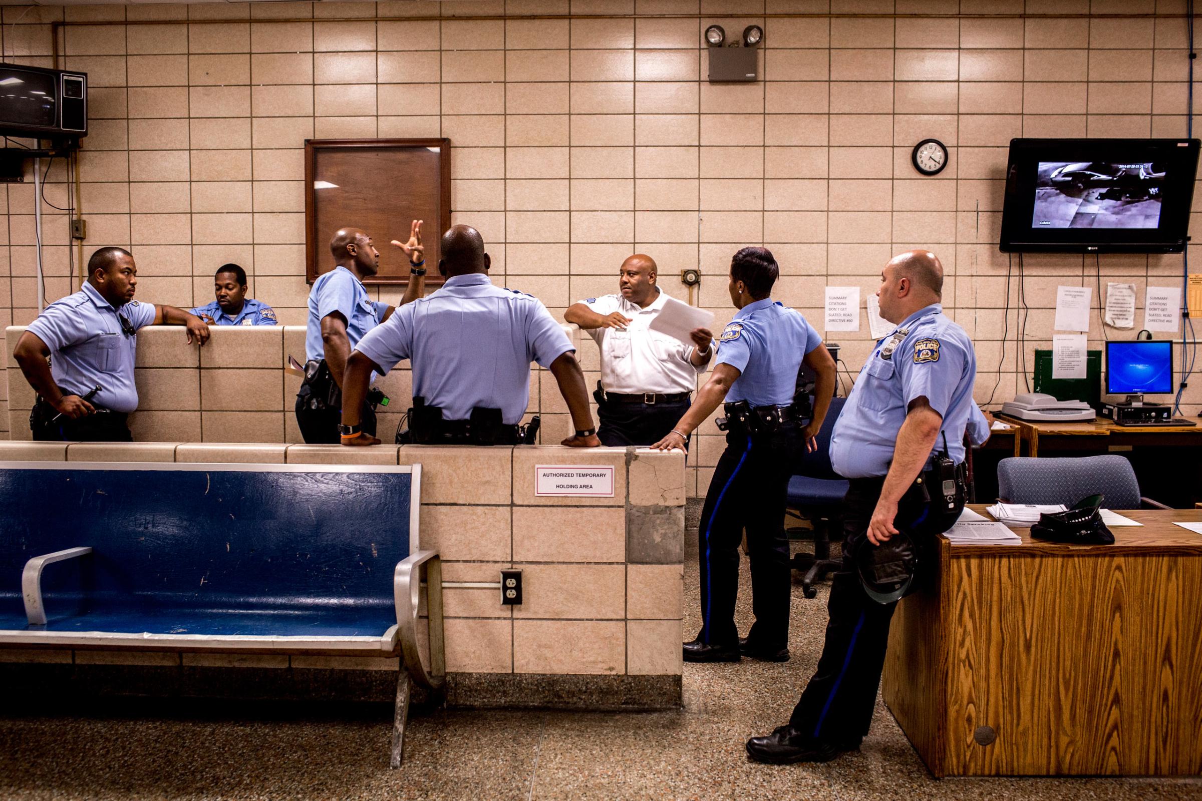 July 27th, 2015. Philadelphia, PA. Sergeant Rodney Linder, center, speaks to a group of officers before they head out on patrol for the evening. (Natalie Keyssar)