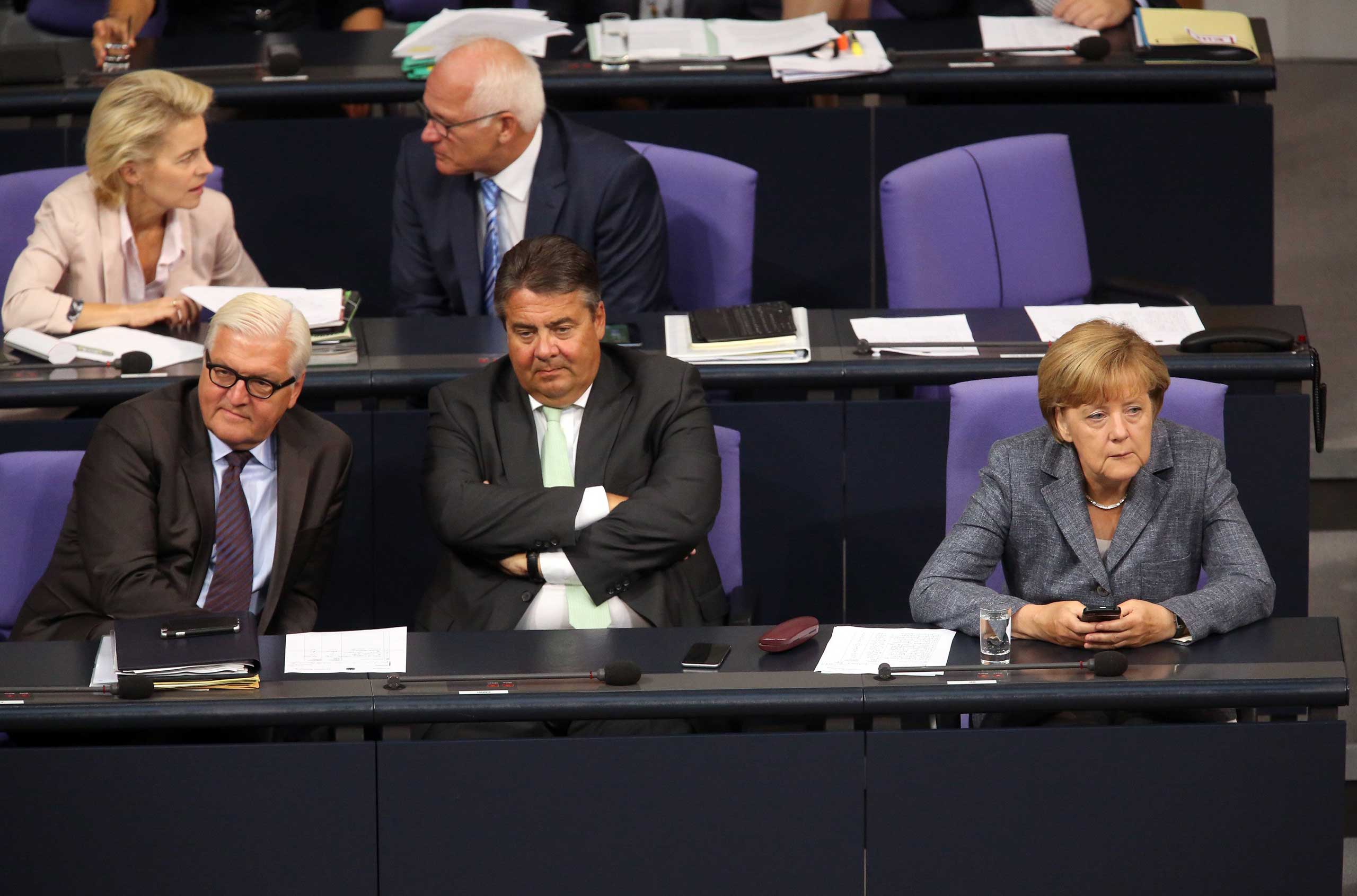 Foreign Minister Frank-Walter Steinmeier, Vice Chancellor and Economy and Energy Minister Sigmar Gabrie and German Chancellor Angela Merkel attend a meeting of the Bundestag, in Berlin, on Aug. 19, 2015. (Adam Berry—Getty Images)