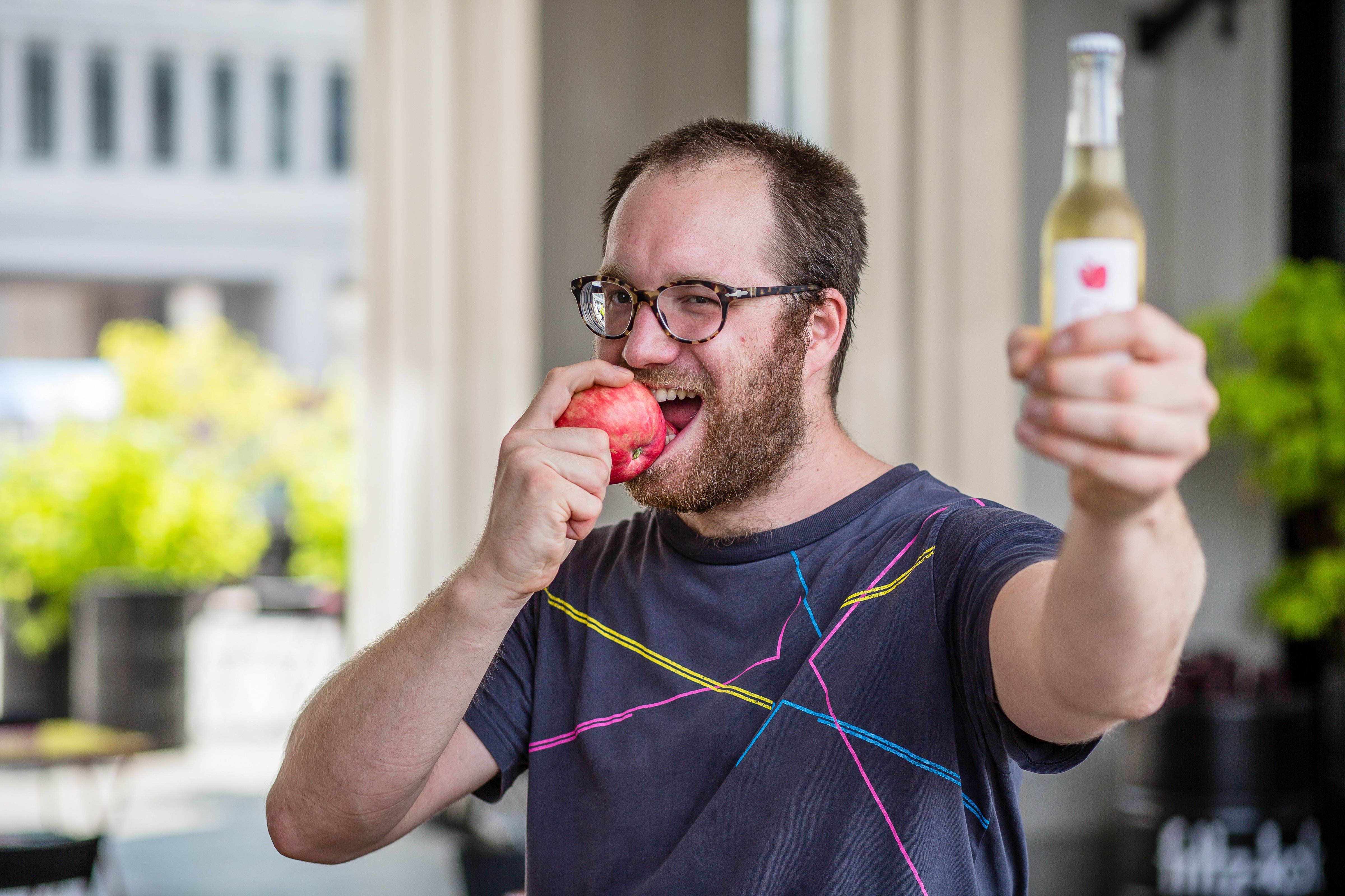 Jozef Czarnocki, owner of a popular Warsaw bar, is biting an apple and hoding a bottle of Polish cider to show his support for Twitter campaign "#eatapples to spite Putin", in Warsaw on July 31, 2014. (WOJTEK RADWANSKI—AFP/Getty Images)