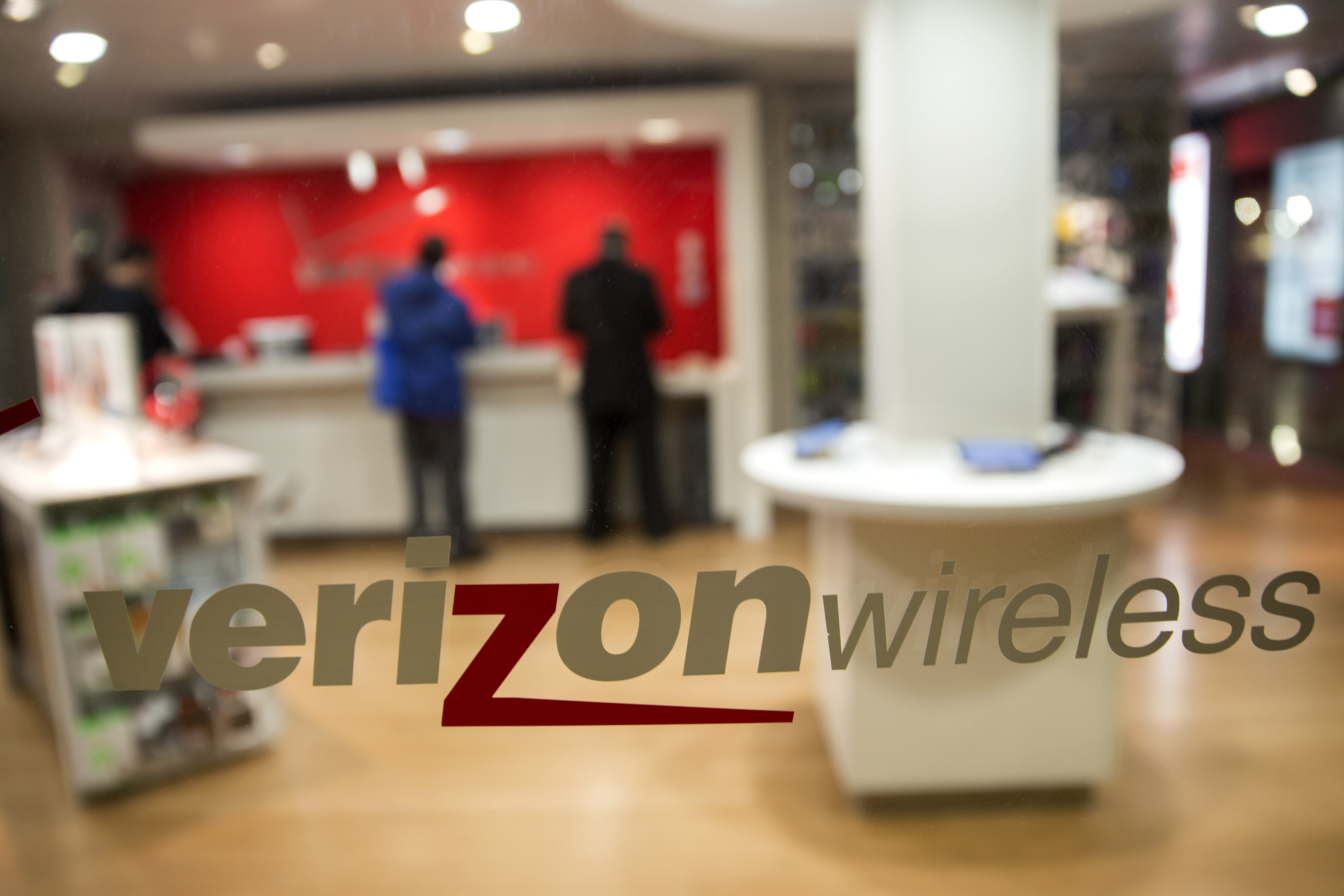 The Verizon Wireless logo is displayed on a window at a retail store in Washington, D.C. on Oct. 23, 2014. (Bloomberg/Getty Images)