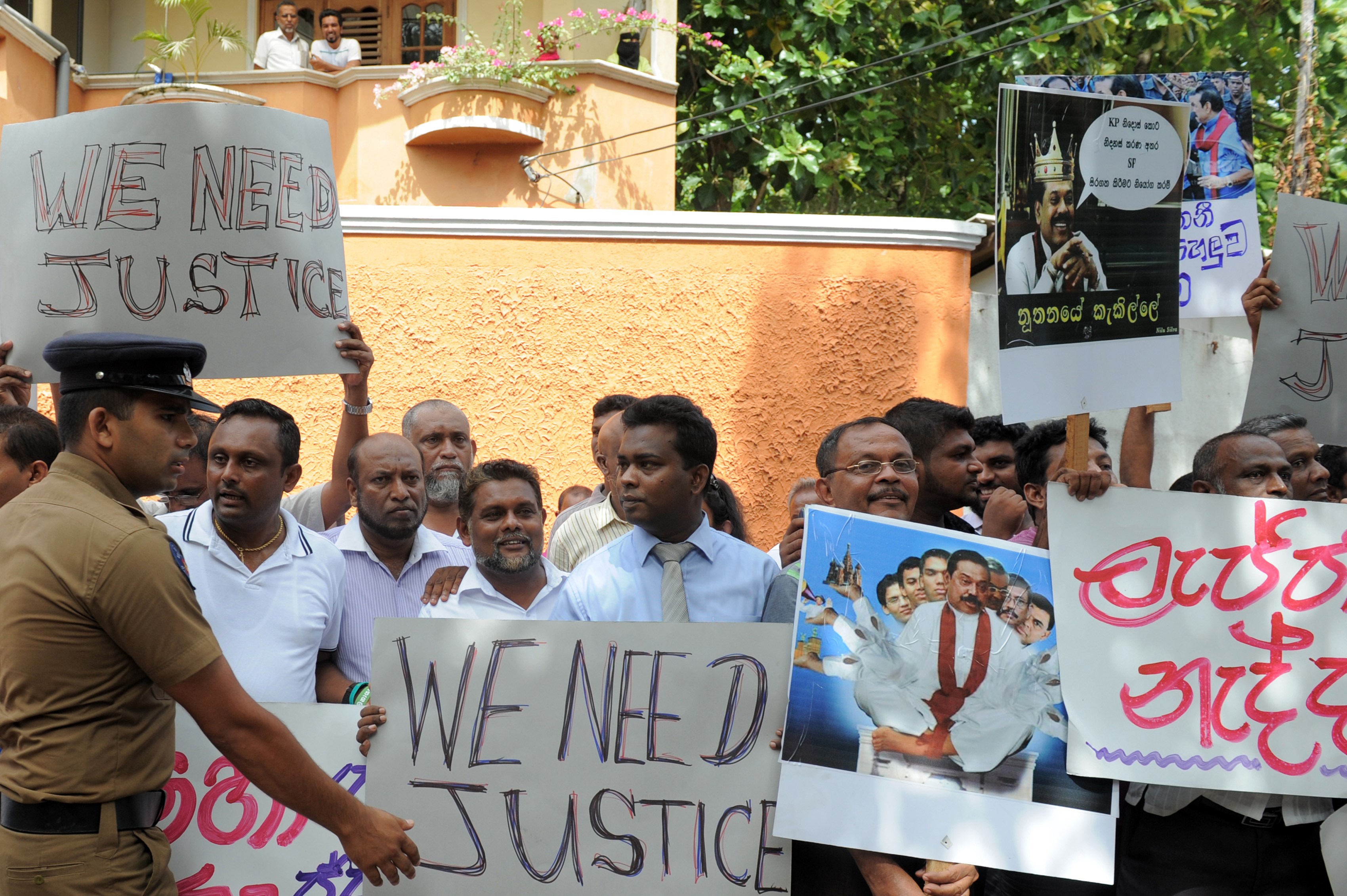 Anti-Rajapakse activists carried placards denouncing the former leader and his administration as the remains of Sri Lankan rugby player Wasim Thajudeen leave the burial ground of the Dehiwela mosque in Colombo on August 10, 2015, after the body was exhumed to be sent to the Judicial Medical Officer. (LAKRUWAN WANNIARACHCHI—AFP/Getty Images)