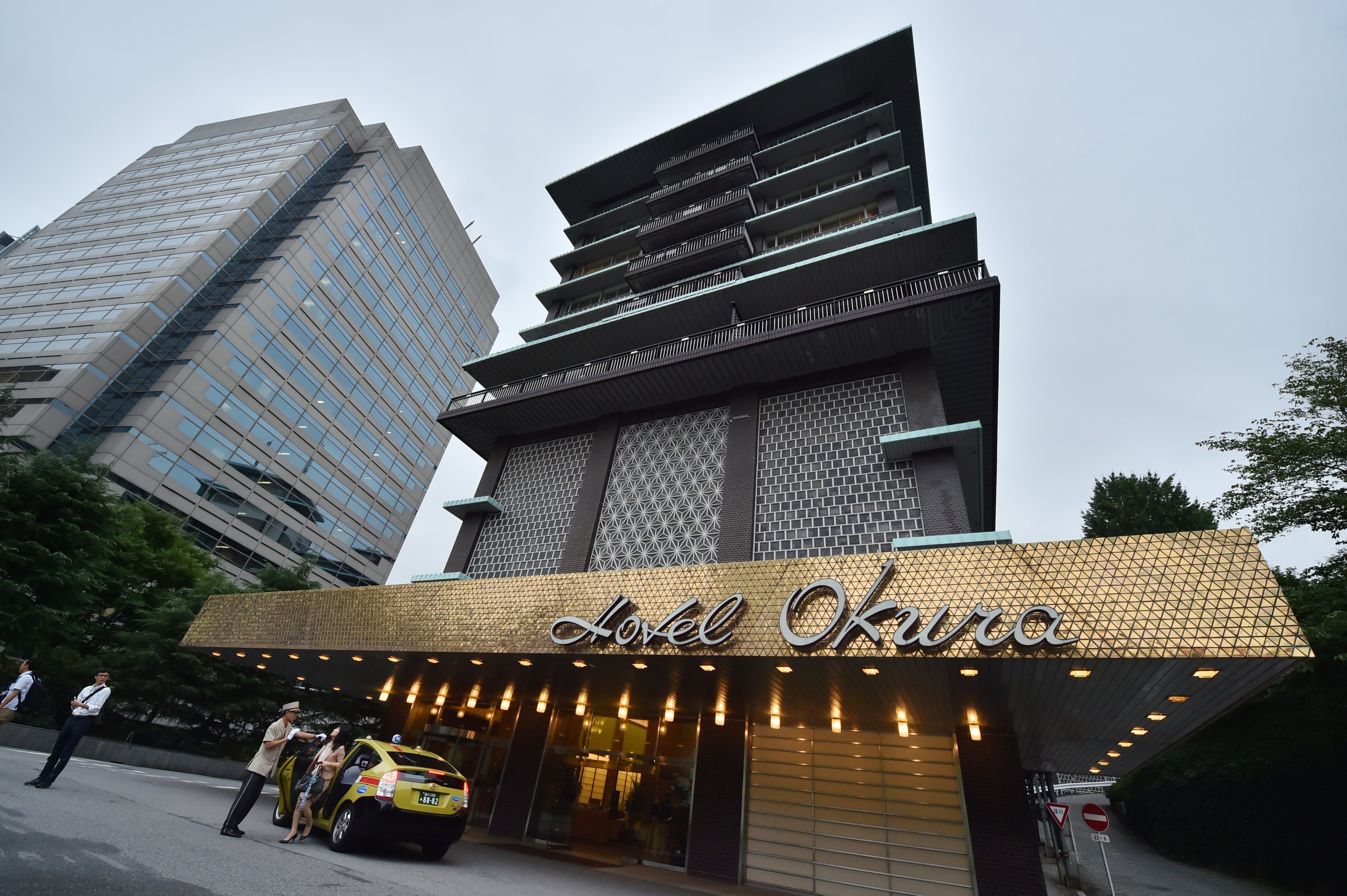 An employee of Japan's iconic Hotel Okura greets customers at an entrance in Tokyo on Aug. 31, 2015 (Kazuhiro Nogi—AFP/Getty Images)
