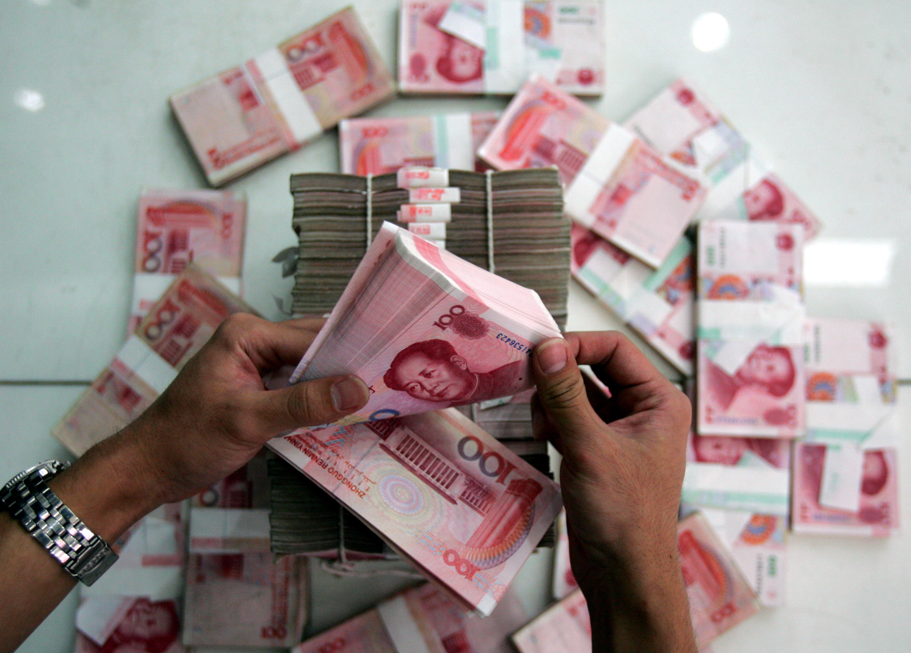 A clerk counts stacks of Chinese yuan at a bank on July 22, 2005 in Beijing, China. (China Photos&mdash;Getty Images)