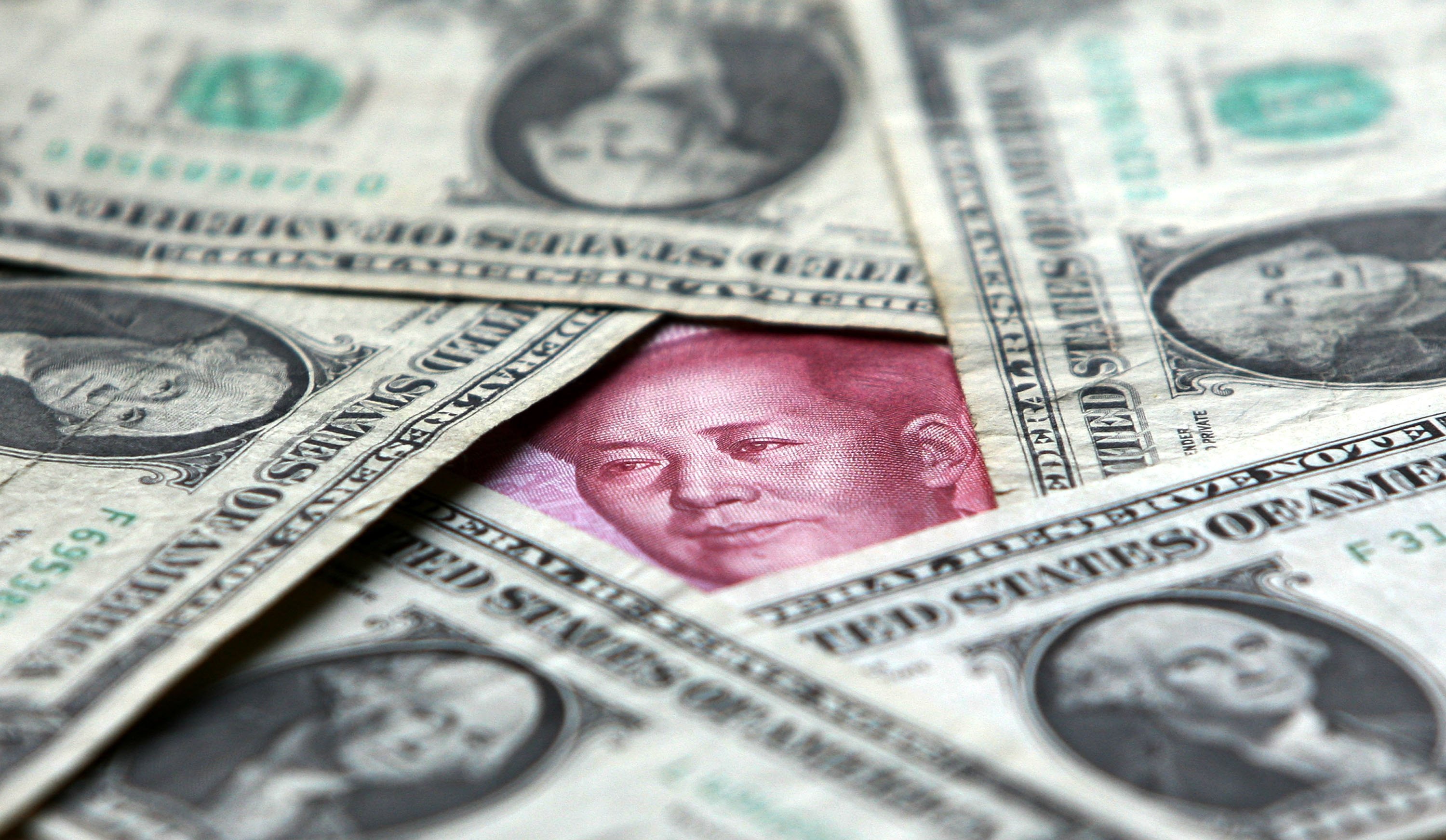 Dollars and yuan notes are seen at a bank on May 15, 2006 in Beijing. (China Photos—;Getty Images)