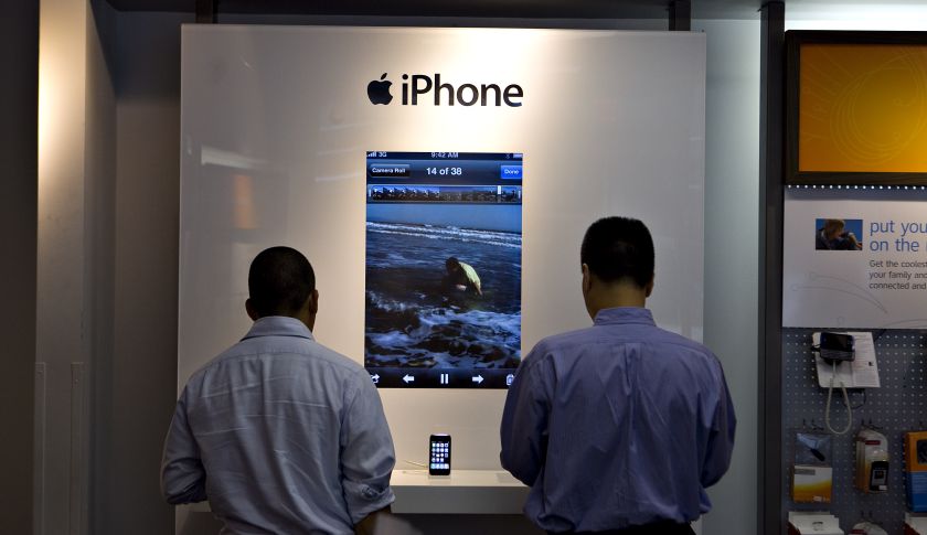Customers look over iPhone 3GS handsets inside an AT&amp;T store