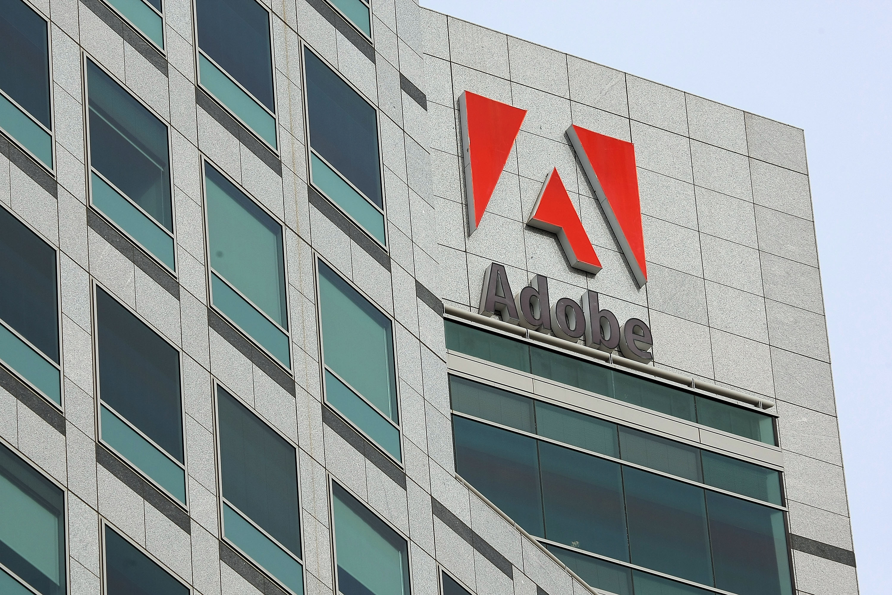 The Adobe logo is displayed on the side of the Adobe Systems headquarters January 15, 2010 in San Jose, California. Adobe Systems has added 20 new wind turbines to their rooftops in an attempt to harness wind energy to help power their offices. (Justin Sullivan&mdash;Getty Images)