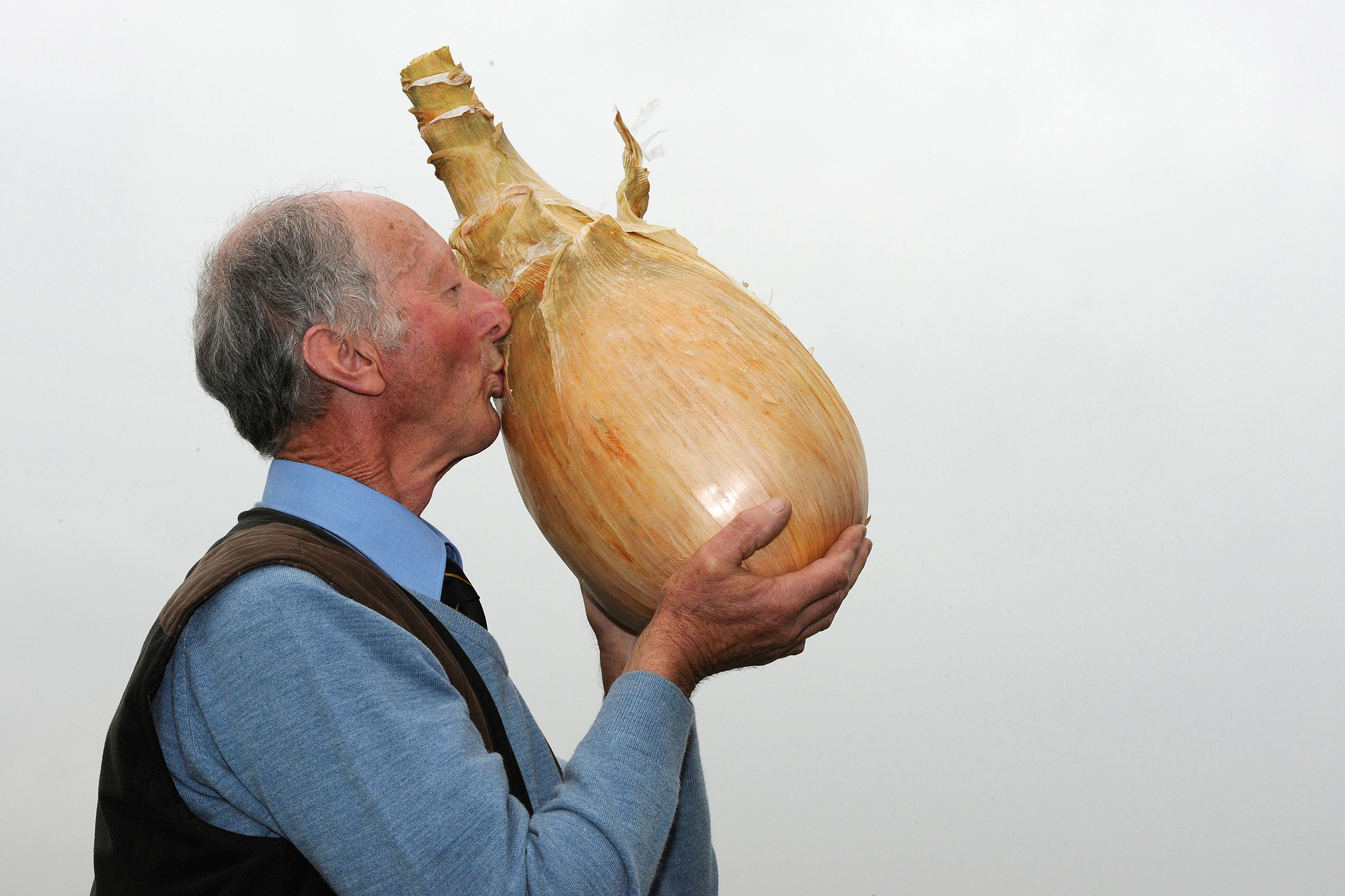 Grower Pete Glazebrook poses for photographers with his onion weighing 17lb 15.5oz  at the Harrogate Autumn Flower Show in Harrogate, northern England September 16, 2011. (Nigel Roddis—Reuters)