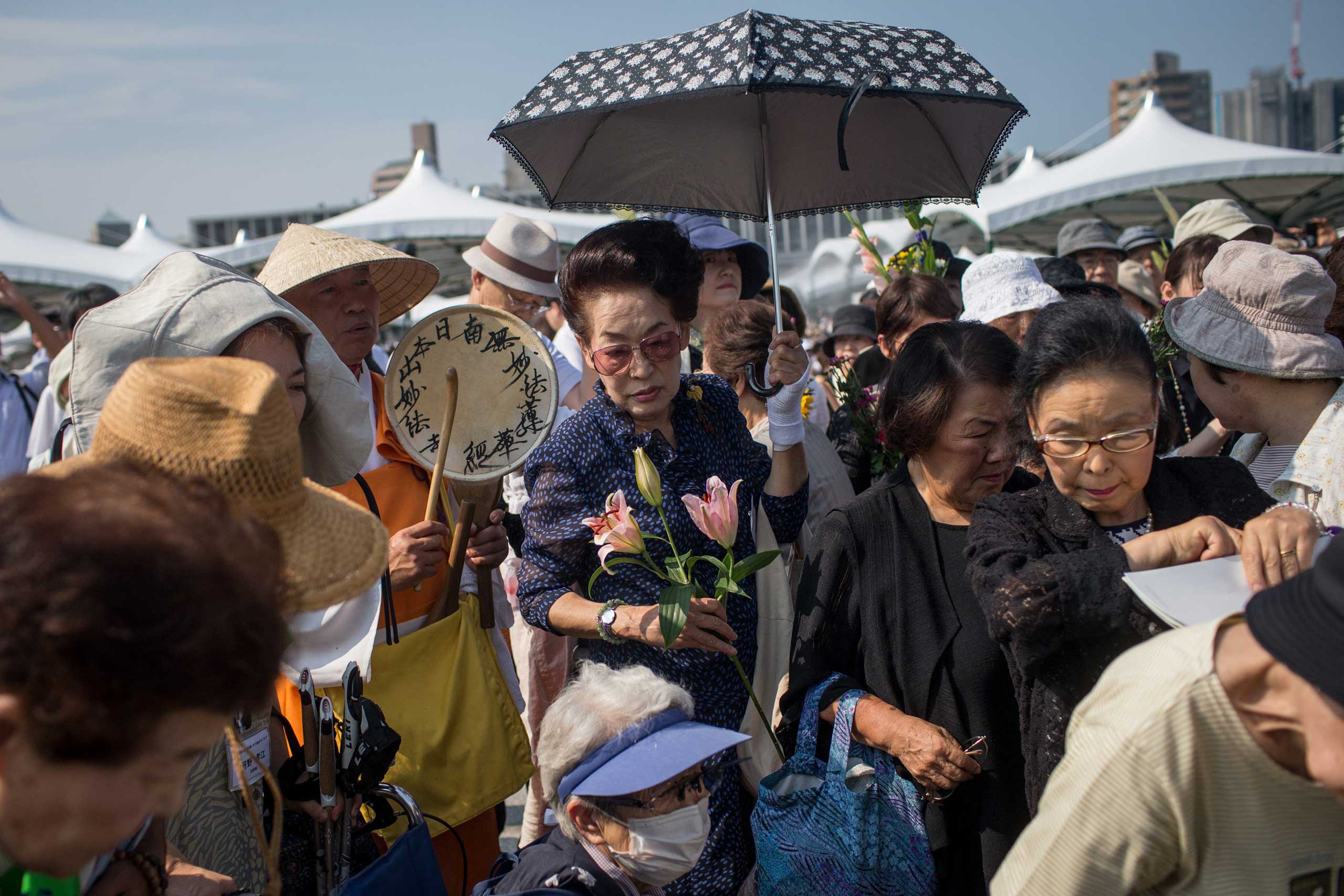 People crowd around to lay flowers at the Hiroshima Peace Memorial after the 70th anniversary ceremony of the atomic bombing of Hiroshima at the Hiroshima Peace Memorial Park, on  on Aug. 6, 2015.