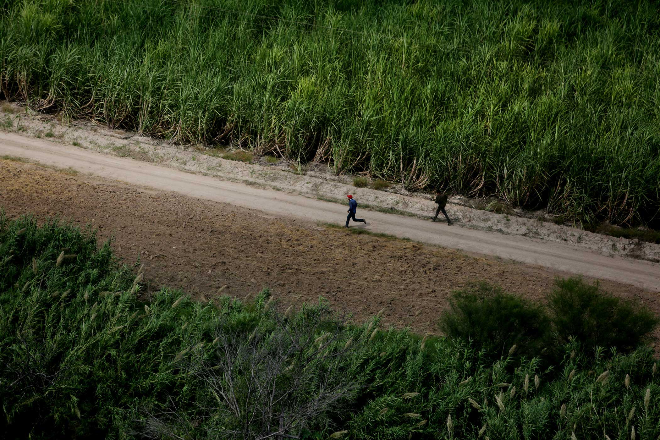 Two suspected migrants run away from the Border Patrol near the banks of the Rio Grande River in Mission, Texas.