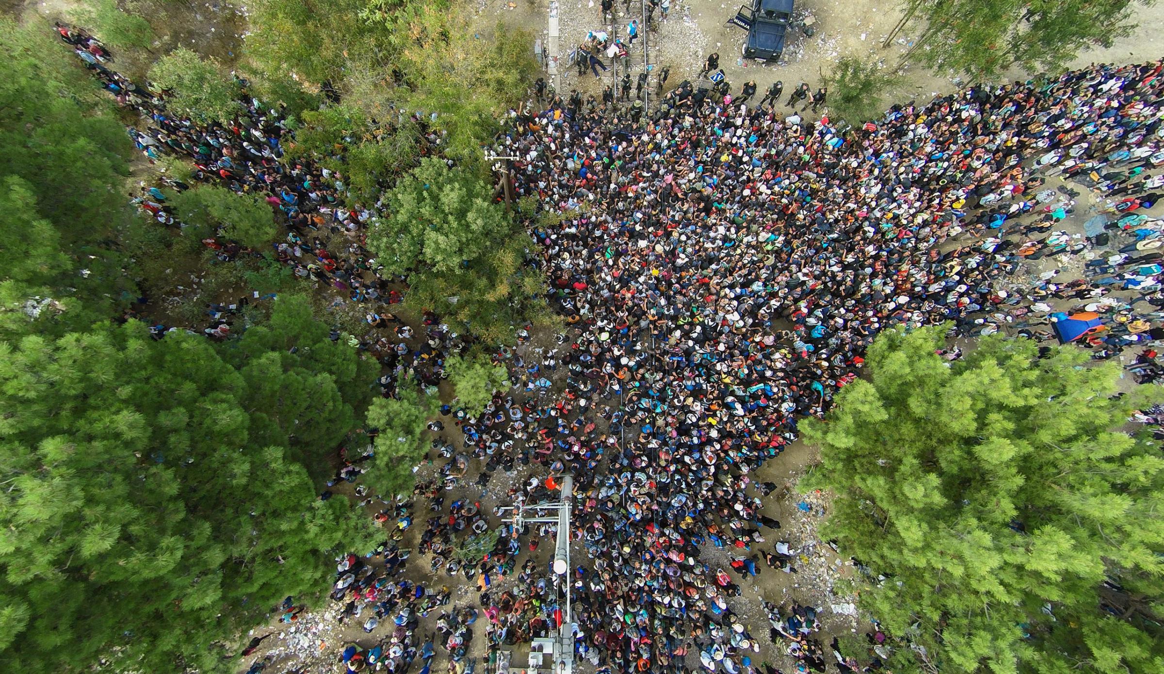 epaselect epa04891581 An aerial view taken from a drone of migrants queueing to pass the Greek-FYROM border to Gevgelija, The Former Yugoslav Republic of Macedonia, from the border village of Idomeni, northern Greece, 21 August 2015. Macedonian police clashed with thousands of migrants attempting to break into the country after being stranded in no-man's land overnight, marking an escalation of the European refugee crisis for the Balkan country. Macedonia had closed the border to refugees and declared a crisis situation in the border zone, calling upon the military to curb the inflow of migrants and deploy border patrols. EPA/NIKOS ARVANITIDIS