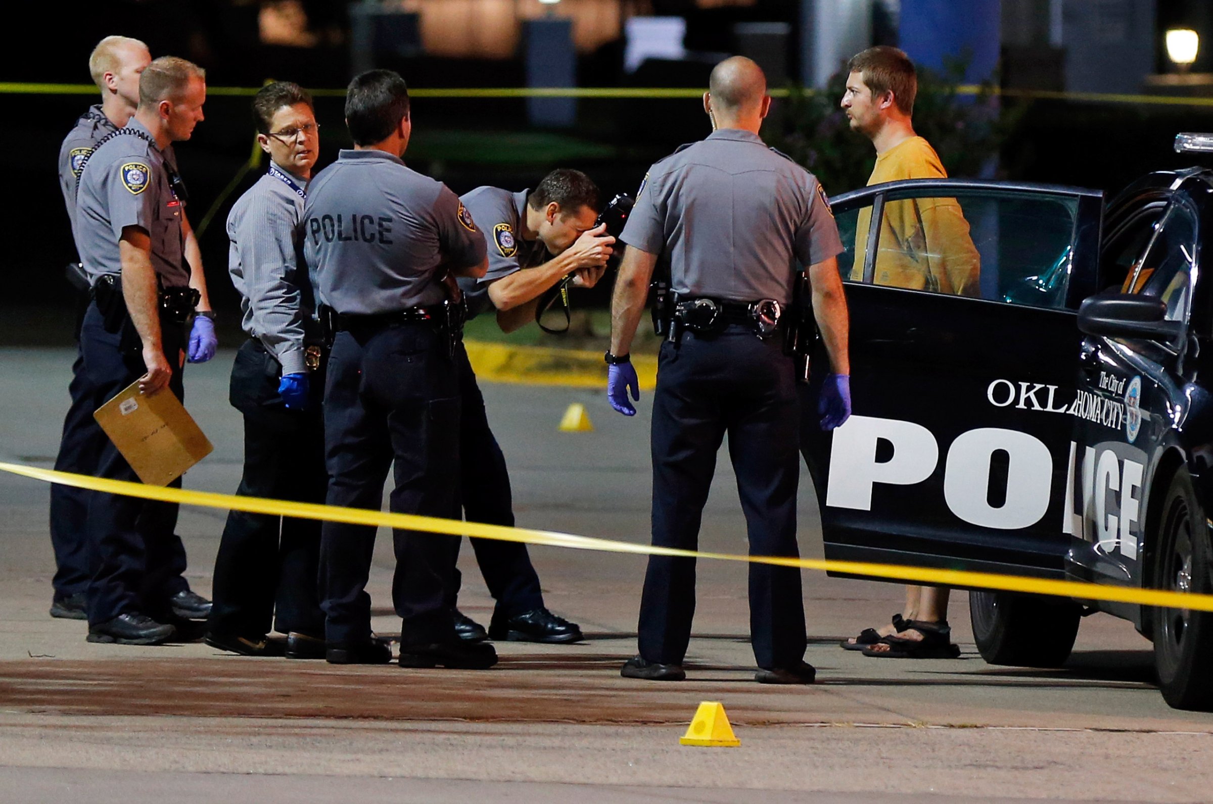 Oklahoma City police take photos of Christian Costello, son of Oklahoma Labor Commissioner Mark Costello, before placing him in a police vehicle, Sunday, Aug. 23, 2015, at the scene where Mark Costello was fatally stabbed in Oklahoma City. Christian Costello was arrested on a first-degree murder complaint, police said. (Nate Billings/The Oklahoman via AP) LOCAL STATIONS OUT (KFOR, KOCO, KWTV, KOKH, KAUT OUT); LOCAL WEBSITES OUT; LOCAL PRINT OUT (EDMOND SUN OUT, OKLAHOMA GAZETTE OUT) TABLOIDS OUT; MANDATORY CREDIT