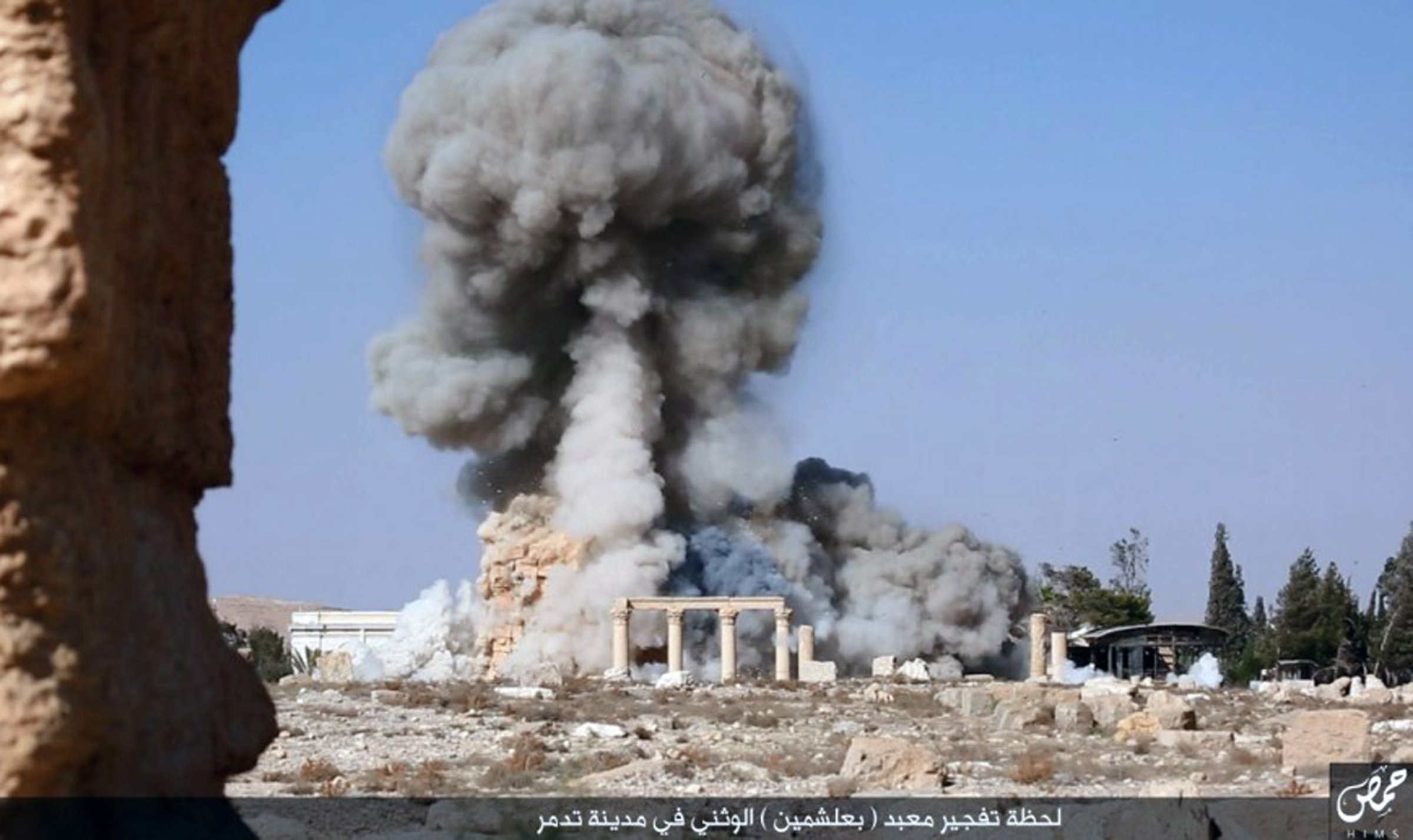 This undated photo released Tuesday, Aug. 25, 2015 on a social media site used by Islamic State militants, which has been verified and is consistent with other AP reporting, shows smoke from the detonation of the 2,000-year-old temple of Baalshamin in Syria's ancient caravan city of Palmyra. A resident of the city said the temple was destroyed on Sunday, a month after the group's militants booby-trapped it with explosives. Arabic at bottom reads, "The moment of detonation of the pagan Baalshamin temple in the city of Palmyra." (Islamic State social media account via AP)