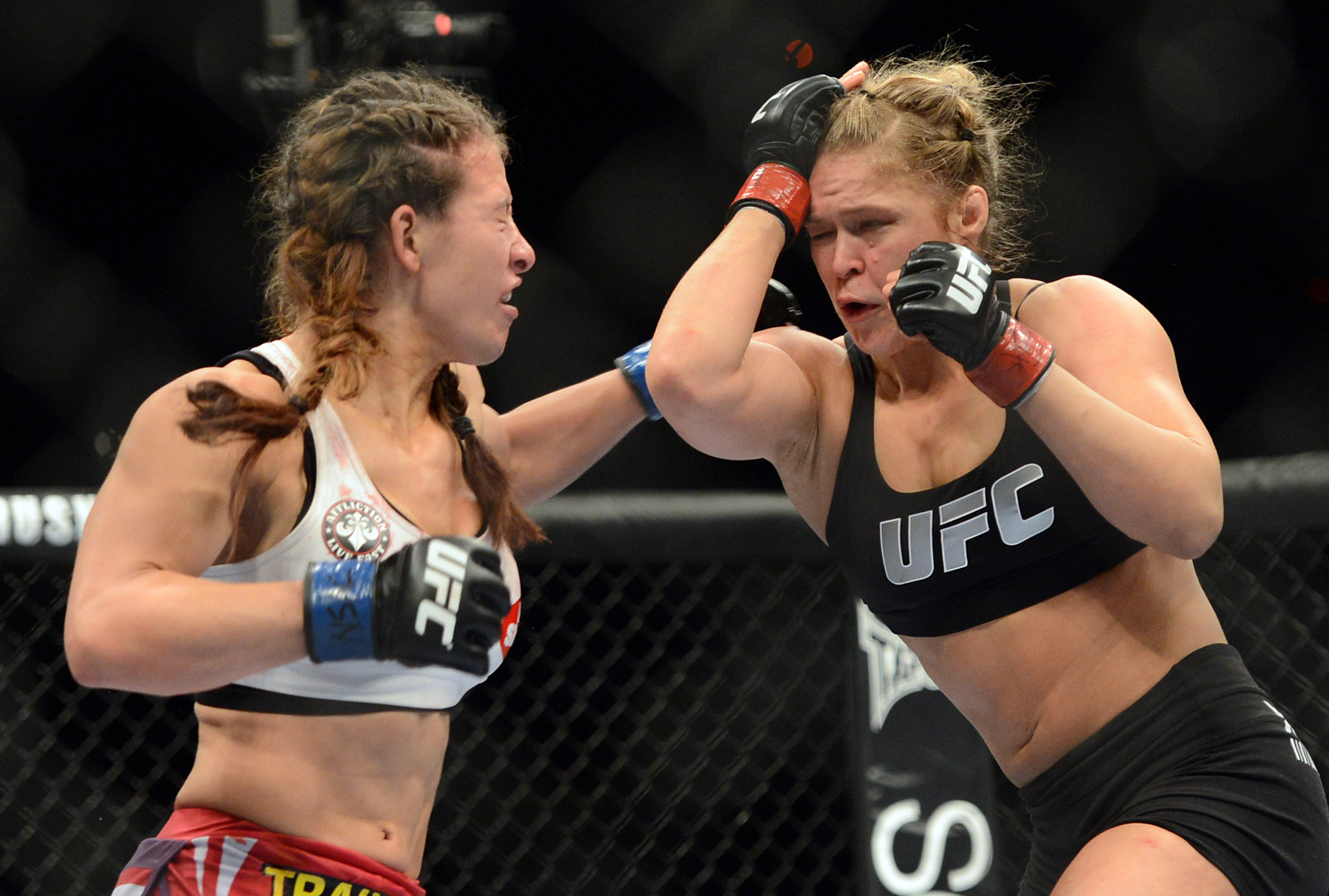 Ronda Rousey (red gloves) and Miesha Tate (blue gloves) fight during the UFC women's bantamweight championship bout at the MGM Grand Garden Arena in Las Vegas on Dec. 28, 2013. (USA Today Sports/Reuters)