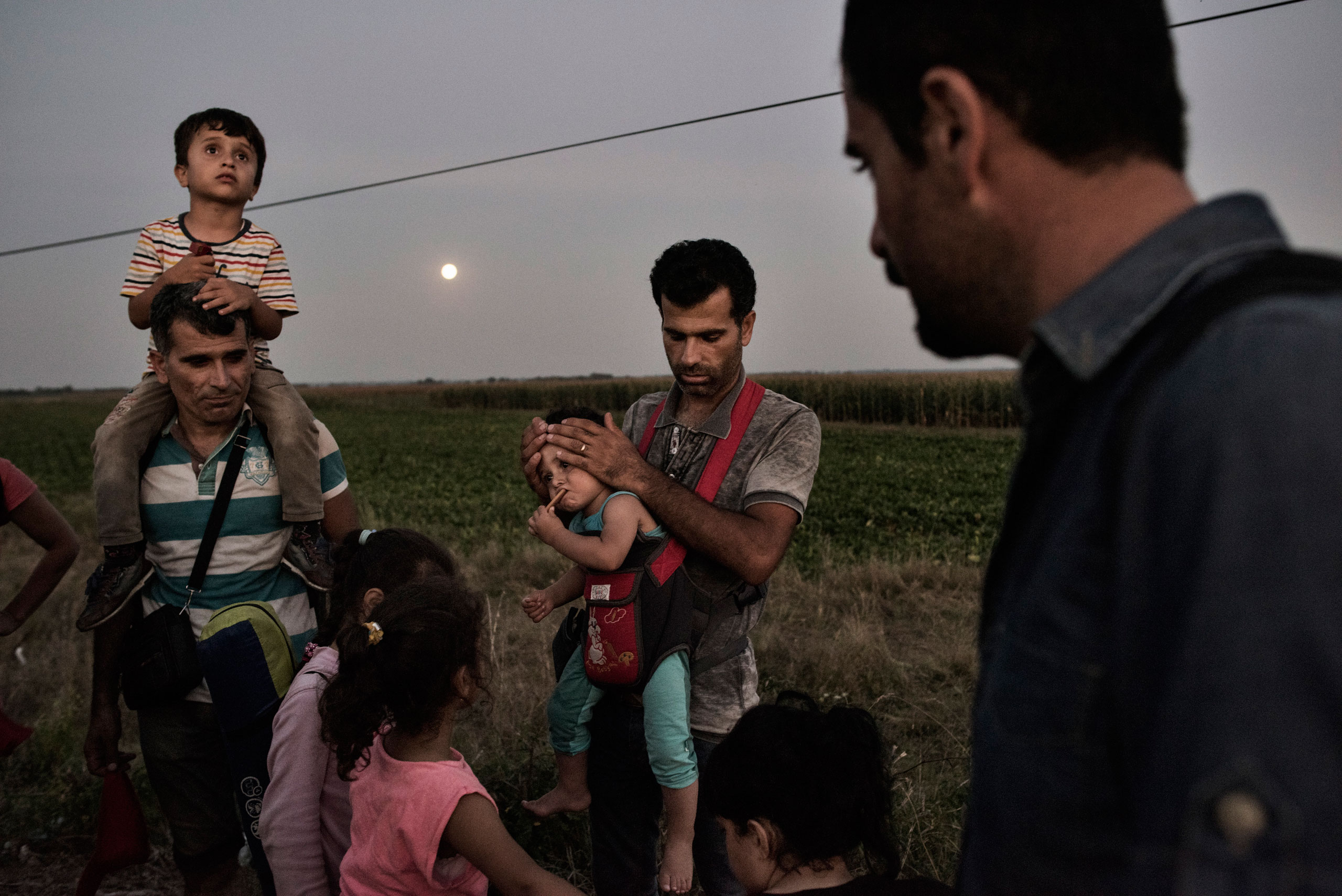 A Syrian family prepares to turn themselves into a Hungarian detention facility for migrants arriving in the European Union in Roszke, Hungary on Aug. 29, 2015. (Yuri Kozyrev—NOOR for TIME)
