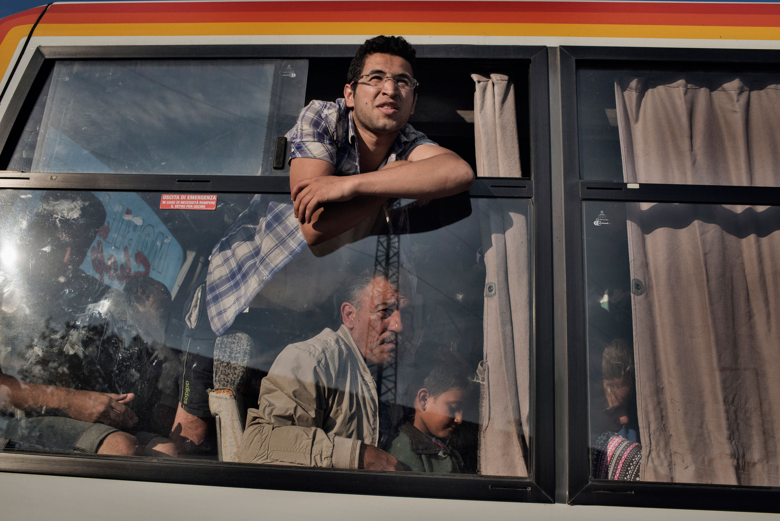 Ghafek Aiad Alsaho, a Syrian migrant, looks through the window of a police bus after border guards caught him crossing illegally from Serbia into Hungary on his way into the European Union in Roszke, Hungary, on Aug. 29, 2015. (Yuri Kozyrev—NOOR for TIME)