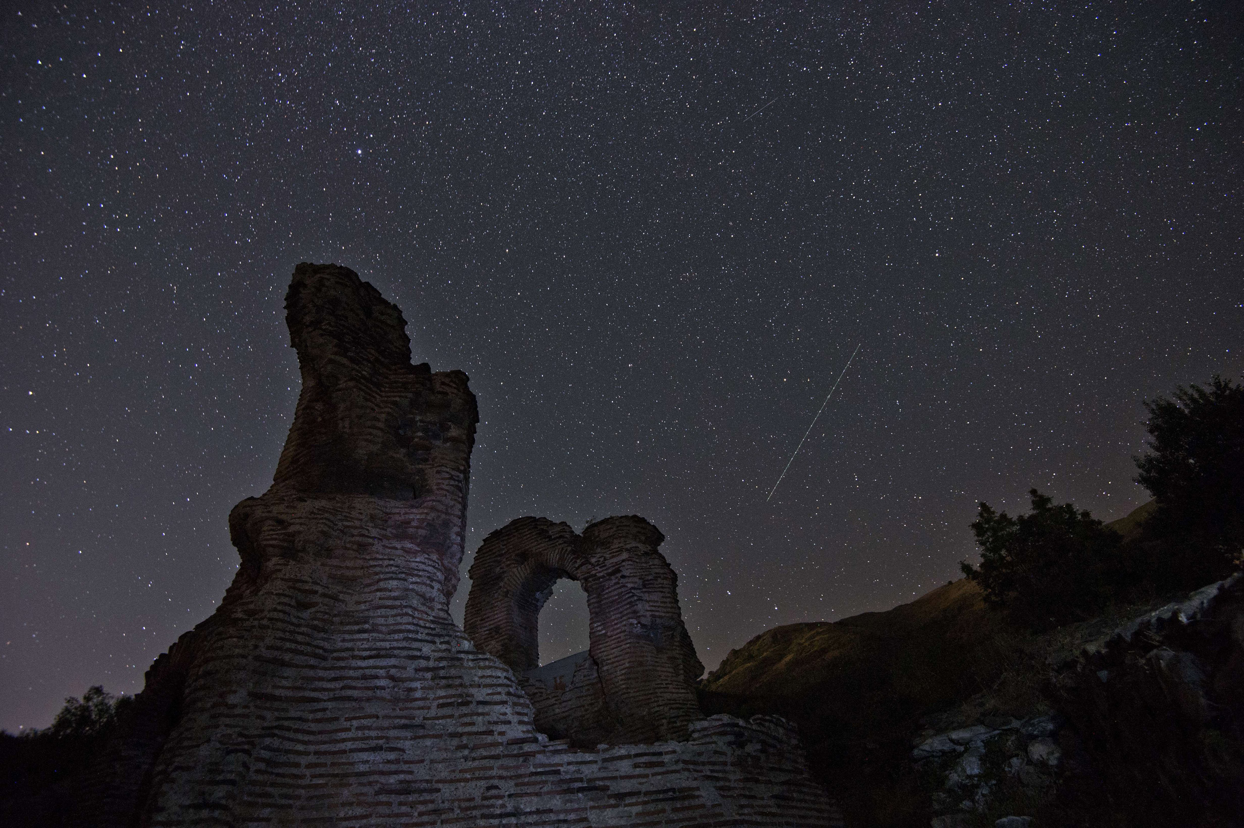 A long exposure image shows a Perseid meteor streak across the night sky over the remains of St. Ilia Roman Christian basilica near the town of Pirdop on Aug. 12, 2015.