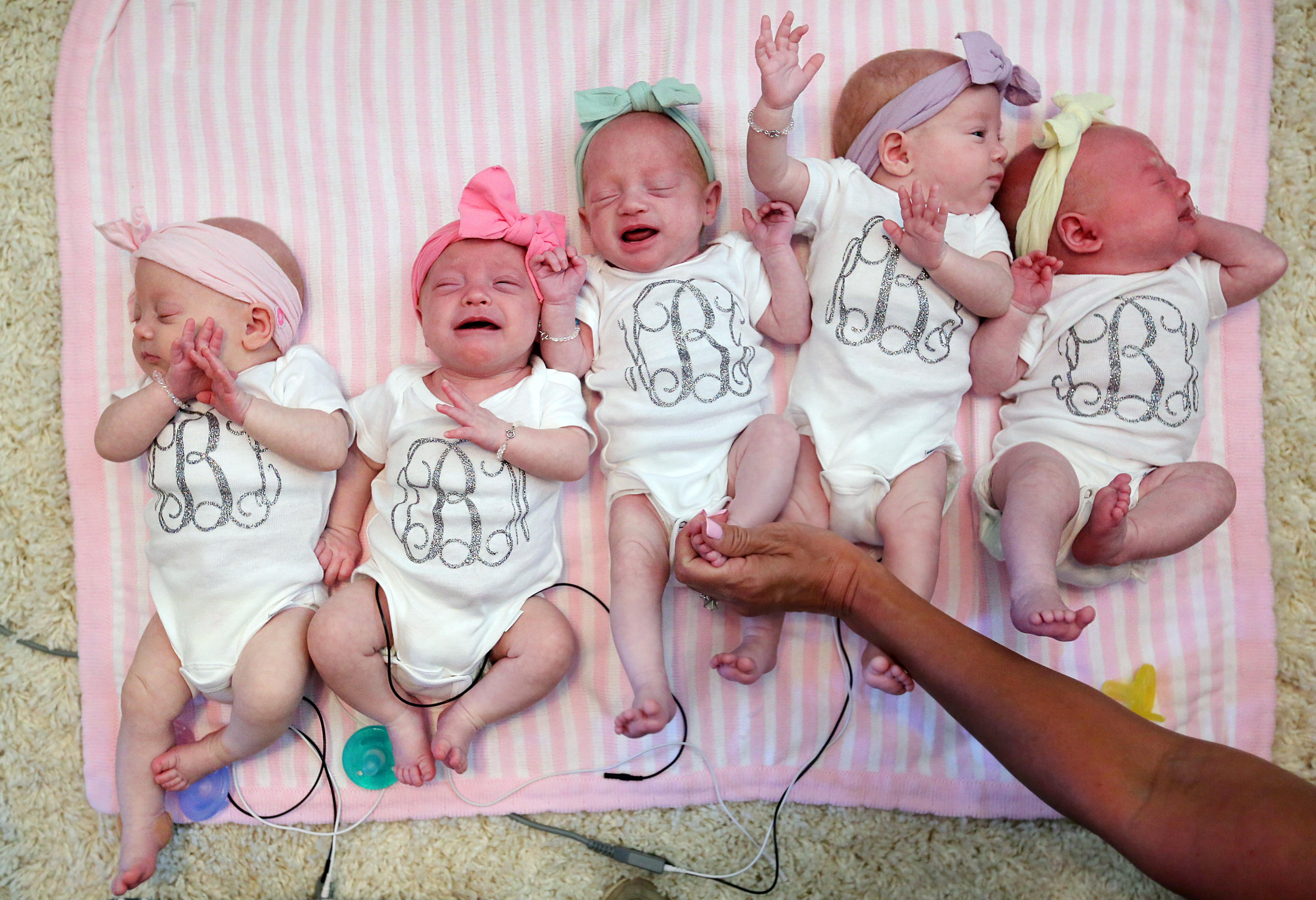 Ava Lane, Olivia Marie, Hazel Grace, Riley Paige, and Parker Kate Busby lie next to one another at home with parents Danielle and Adam Busby in League City, Texas on July 6, 2015. (Mayra Beltran—AP)