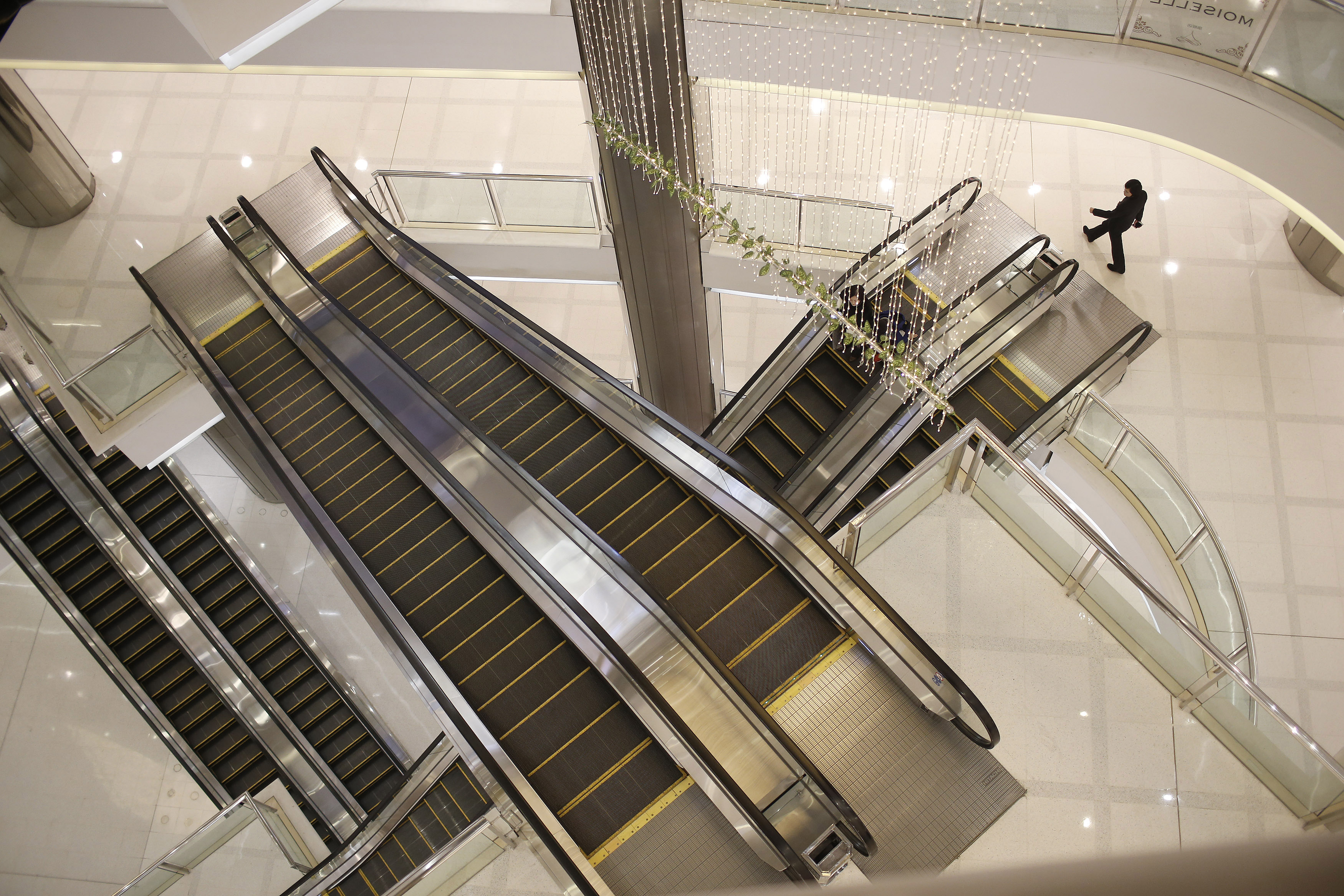 A woman walks next to escalators at a department store in Shanghai, March 8, 2015. (© Aly Song / Reuters—REUTERS)