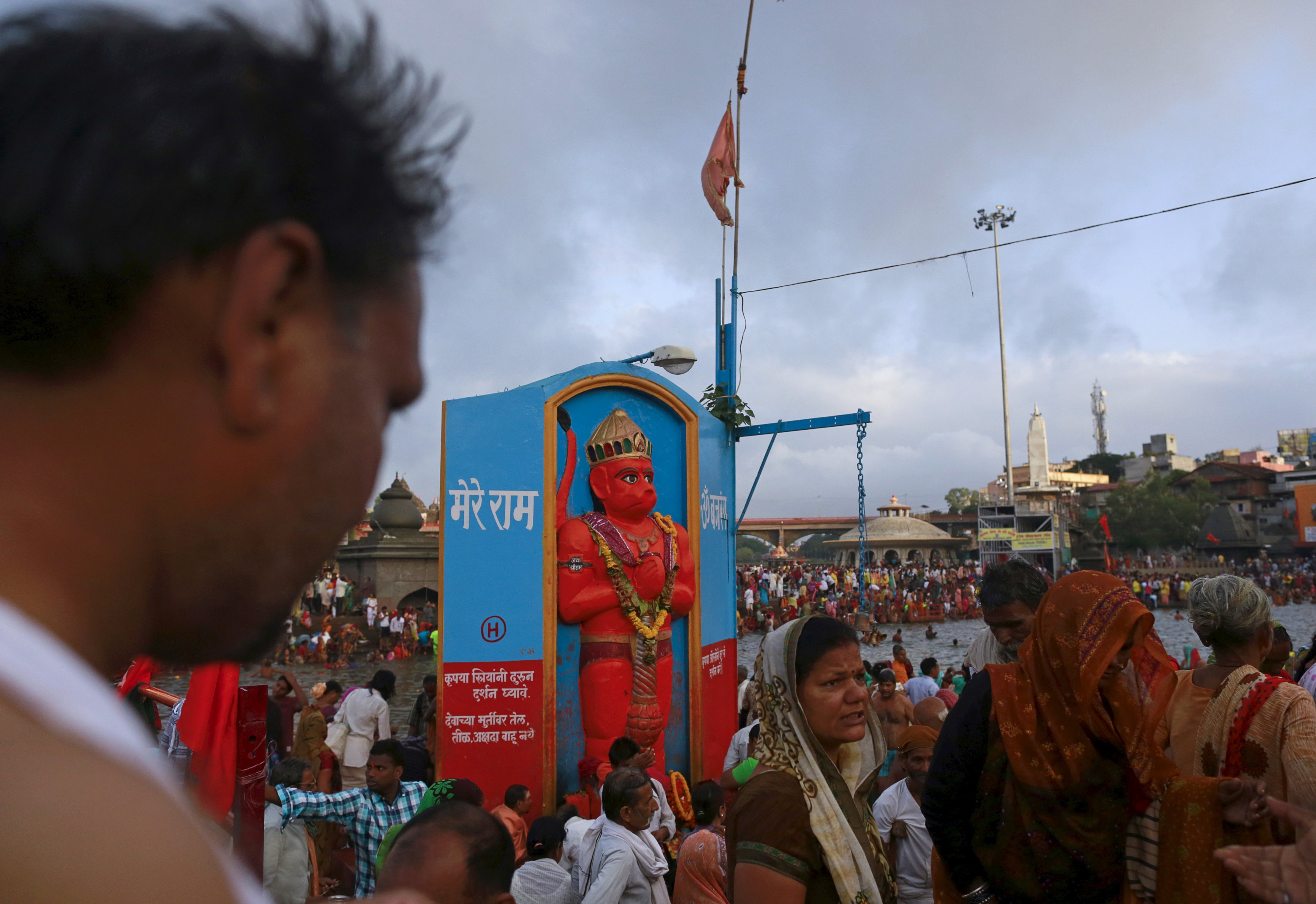Devotees walk past an idol of the Hindu monkey god Hanuman on the banks of Godavari River in Nashik, India, on Aug. 26, 2015 (Danish Siddiqui—Reuters)