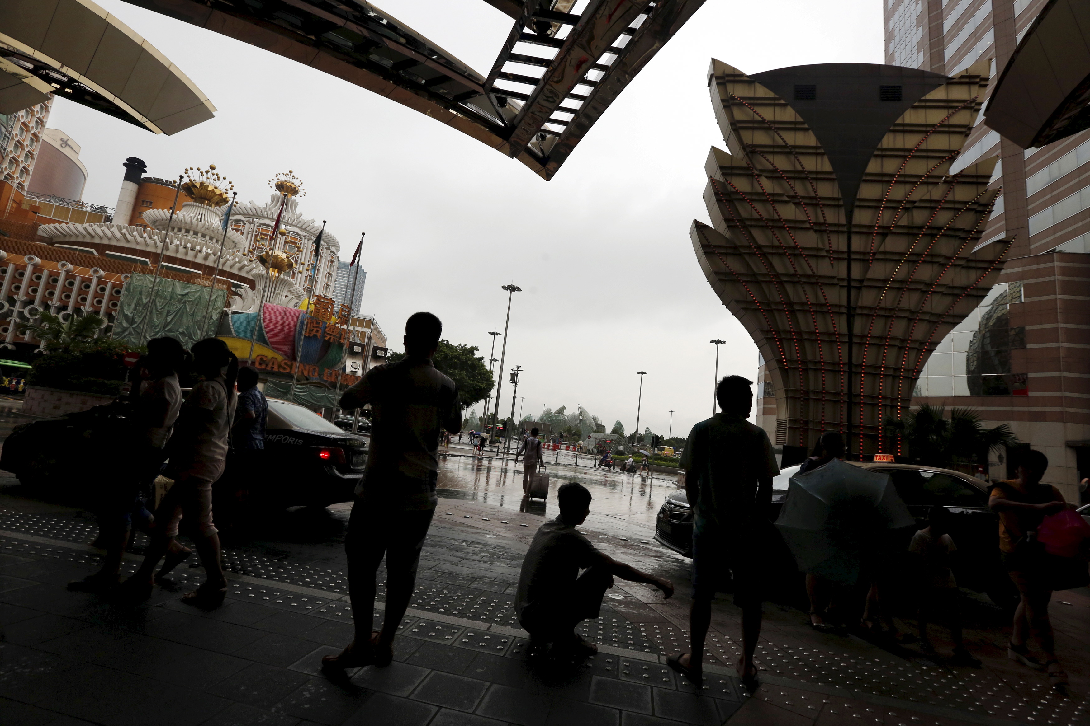 Visitors from mainland China wait outside a casino in Macau