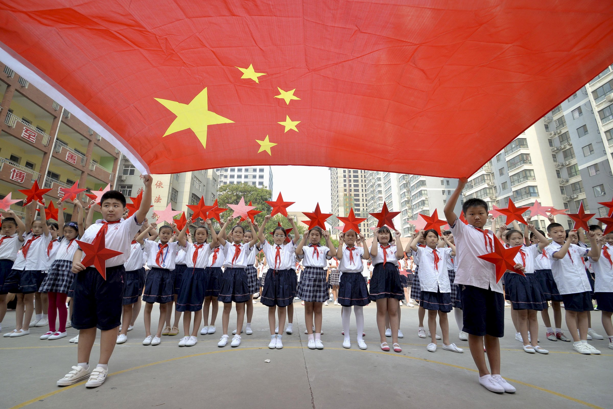 Students pose with a Chinese national flag and red stars during a event to mark the 70th anniversary of the Victory of Chinese People's War of Resistance Against Japanese Aggression and the World Anti-Fascist War, at a primary school in Handan