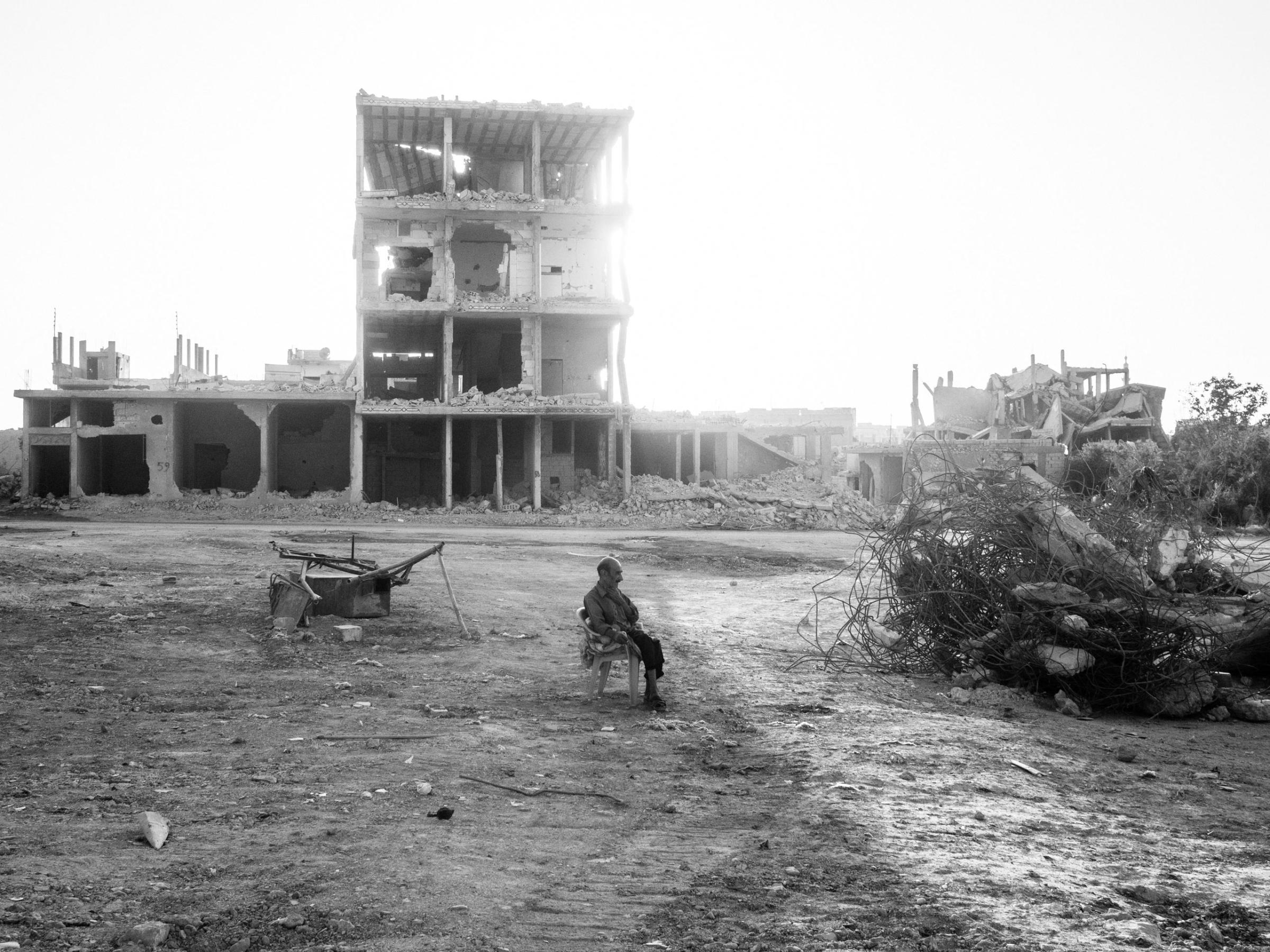 Kobane, Syria. August 8, 2015.A man rests amid rubble in the eastern part of Kobane. In January 2015, the YPG backed by coalition airstrikes succeeded in expelling the Islamic State (IS) from the town. Seventy percent of the city was destroyed by airstrikes and fighting. The YPG now controls the town, which has mostly been reduced to rubble.(Photo by Moises Saman/MAGNUM)