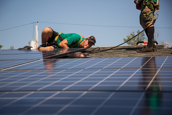 Dave Scarantino, senior installer for SolarCity Corp,   installs solar panels on the rooftop of a home in Kendall Park, N.J., U.S., on Tuesday, July 28, 2014.
