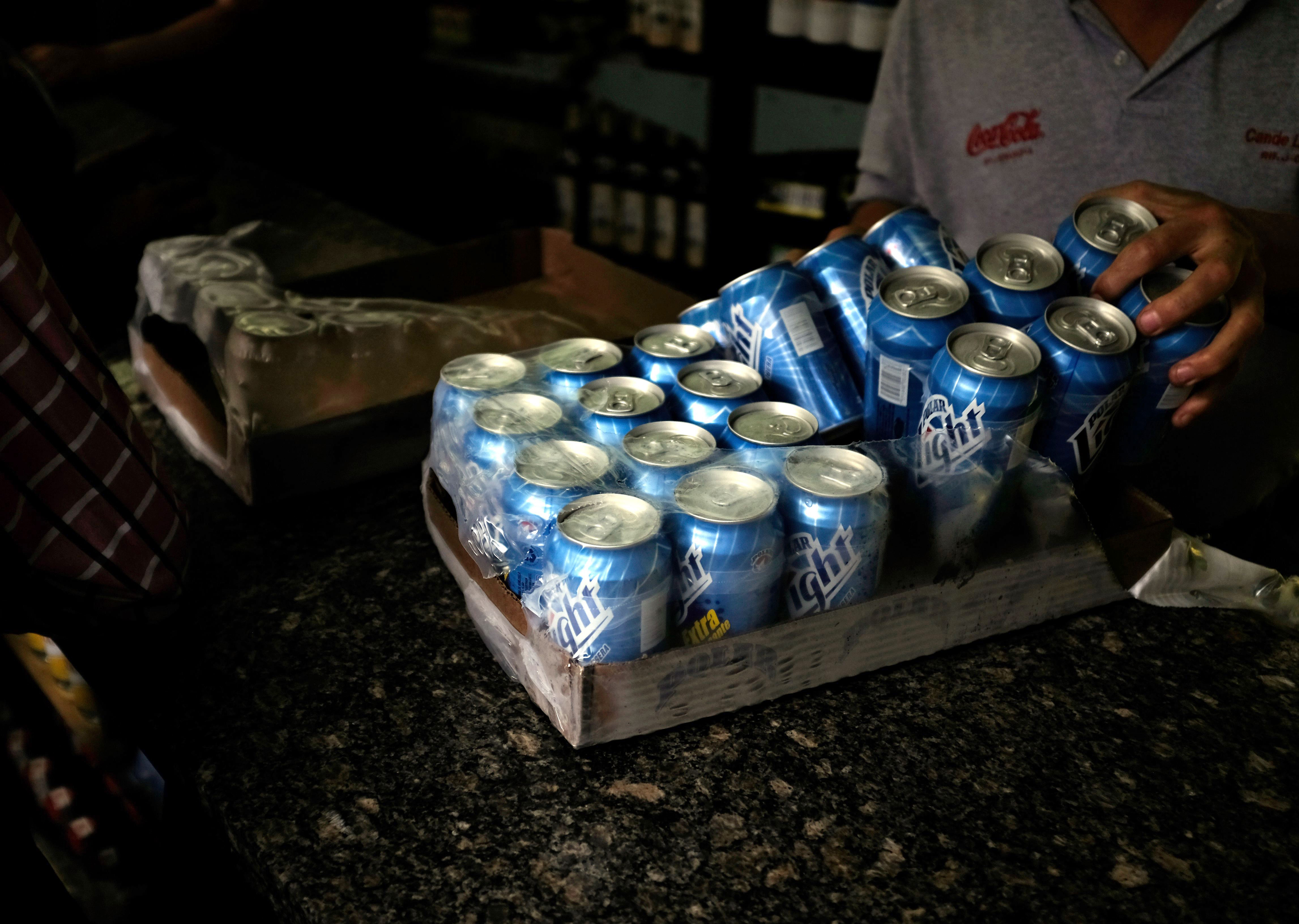 A liquor store worker organizes Polar beer cans in downtown Caracas on July 31, 2015. (Fernando Llano—AP)