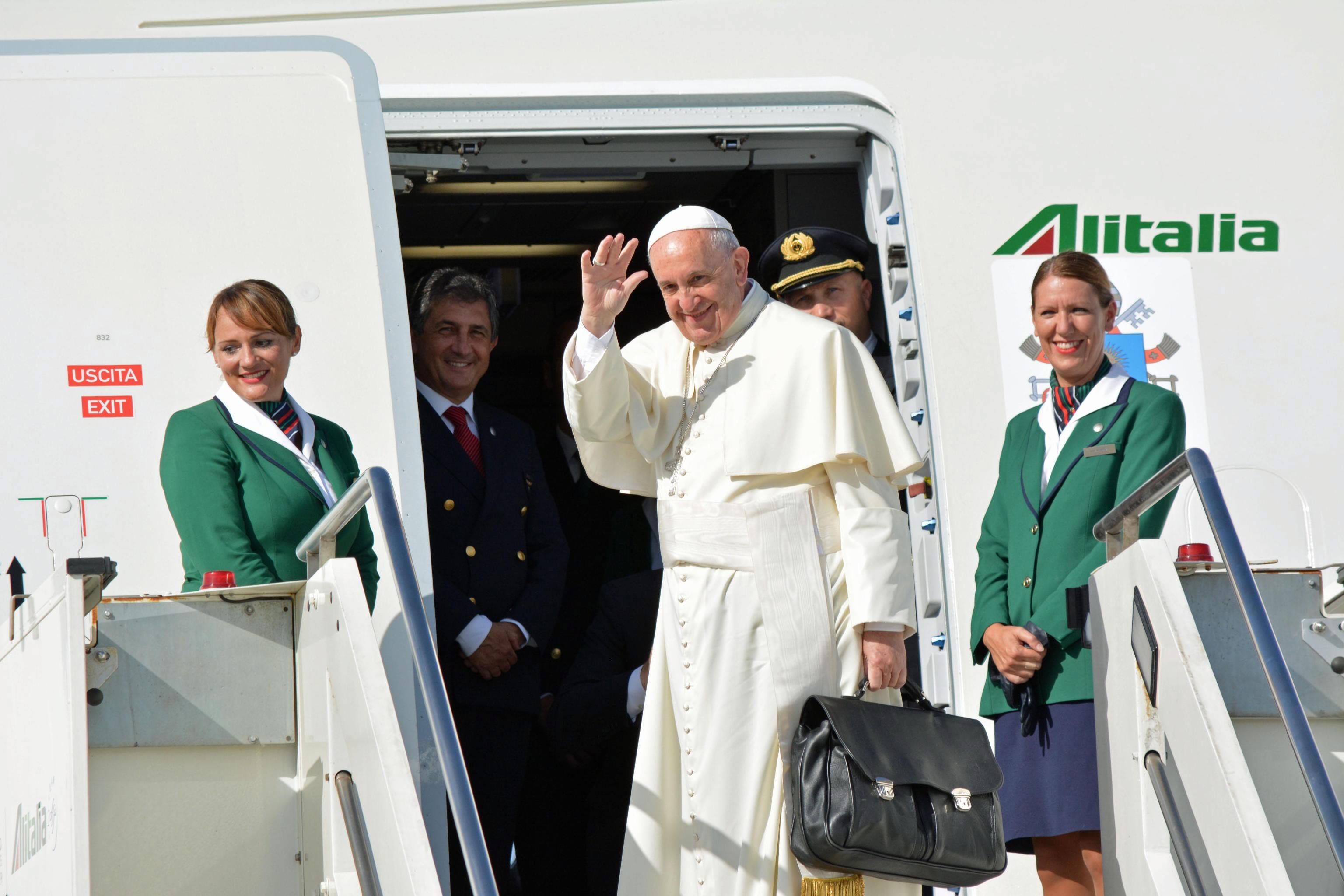 Pope Francis waves to reporters at Fiumicino international airport as he boards his flight to Havana, Cuba, from Rome, on Sept. 19, 2015. (TELENEWS/EPA)