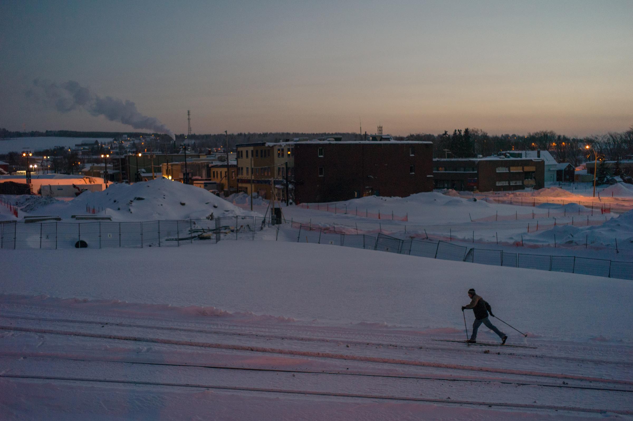 A cross-country skier on the rehabilitated train tracks next to the still-closed Red Zone, December 31 2013. From "Post MÈgantic" by Michel Huneault, winner of the 2015 Lange-Taylor Prize.
