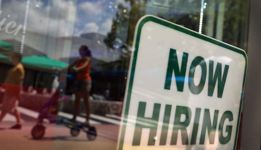 A 'Now Hiring' sign is seen in a storefront window in Miami Beach, Fla. (Joe Raedle&mdash;Getty Images)