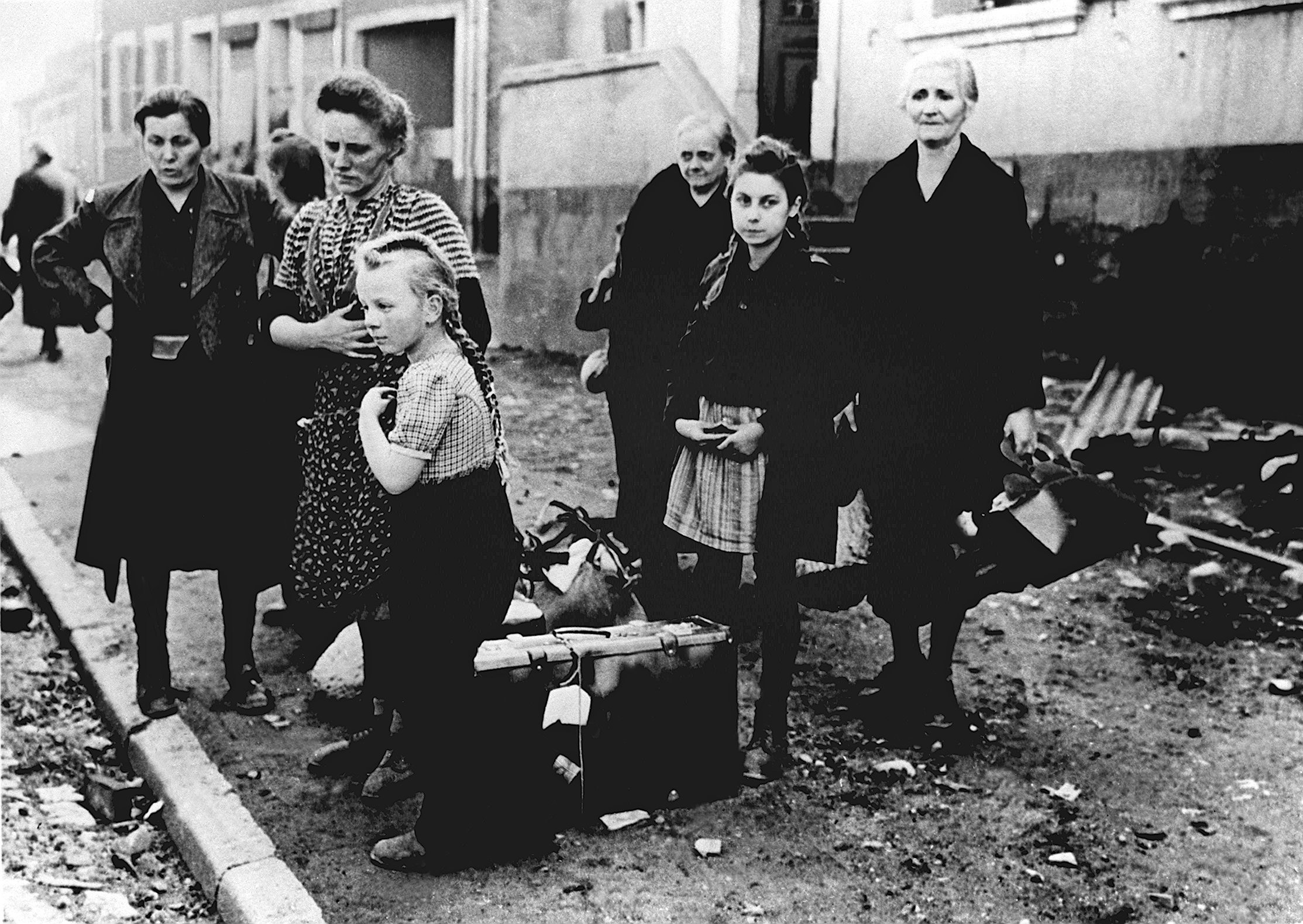 Women and children are standing at the roadside and are waiting for a transport possibility, in 1945.