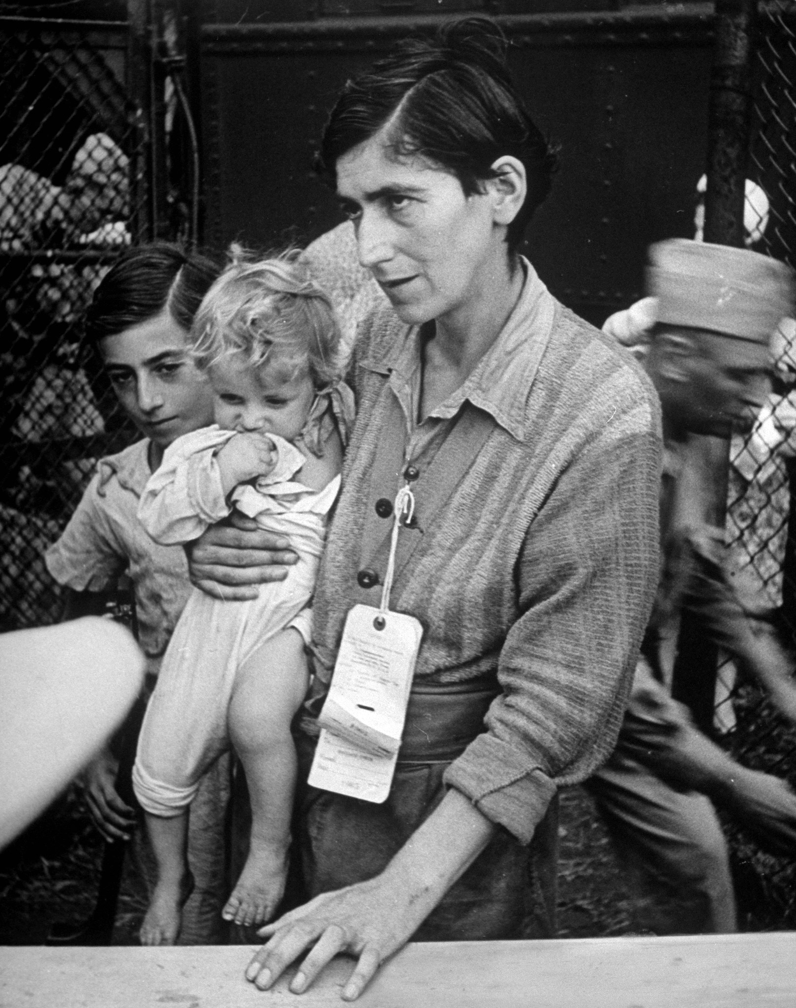 Swiss Jew Eva Bass, formerly a nightclub singer in Paris, entering refugee camp at Fort Ontario, with her children Yolanda and Joachim, whom she carried on a sixty-kilometer trek through the fighting lines to reach American transport ship Henry Gibbins. 1944.