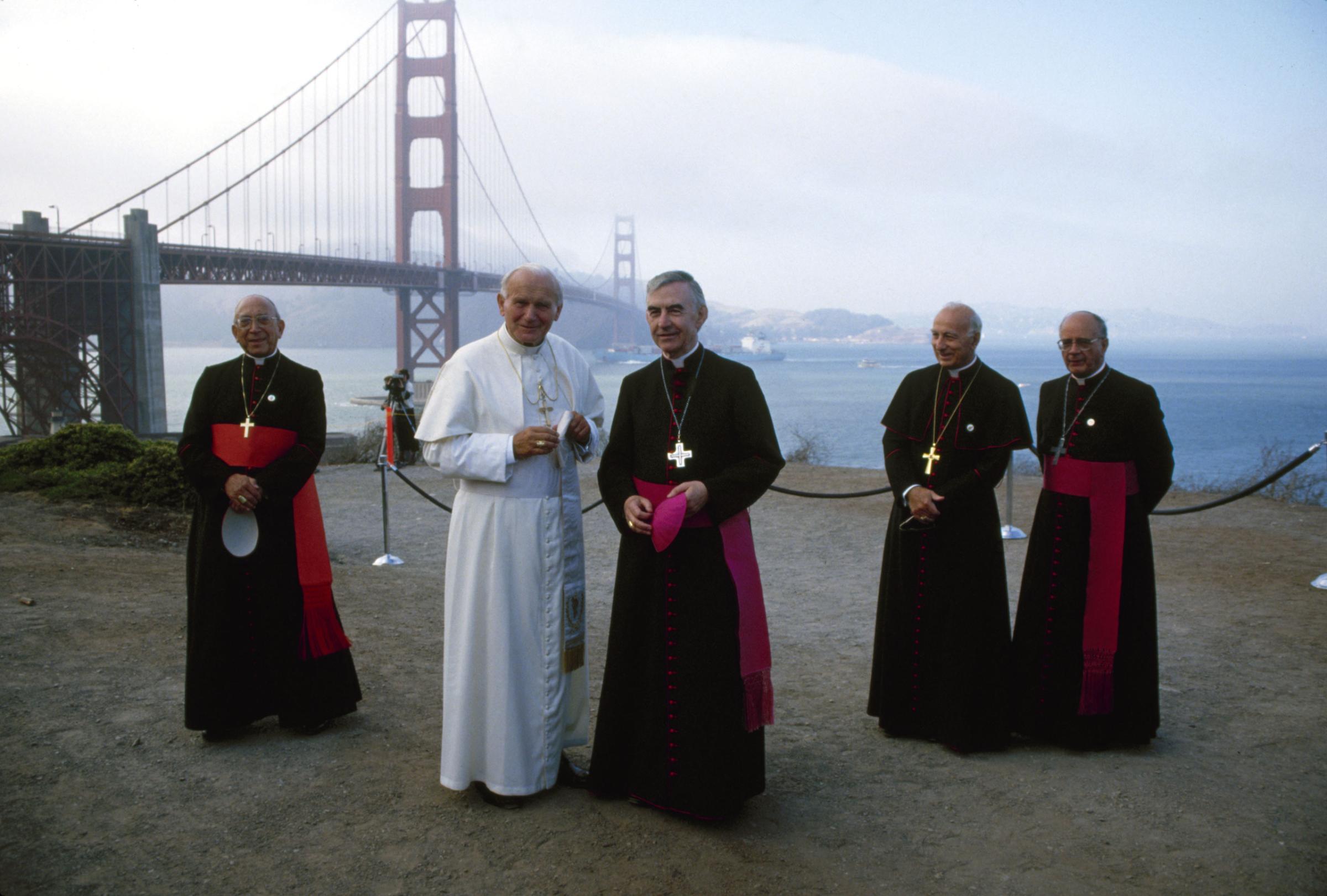 Pope John Paul II (born poses with American Bishop (and later Archibishop) John R. Quinn (center) during a visit to Golden Gate Park, San Francisco, California, September 18, 1987. With them in the background are Italian Cardinal Secretary of State Agostino Casaroli (left), Italian Apostolic Pro-Nuncio to the United States (and later Cardinal) Pio Laghi (second right), and Spanish Archbishop Substitute for General Affairs (and later Cardinal) Eduardo Martinez Somalo (right).