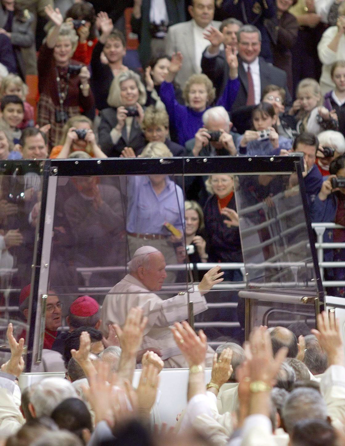 Pope John Paul II waves to the crowd as he arrives to say Mass in his bullet-proof "Popemobile" in St. Louis, January 27, 1999.