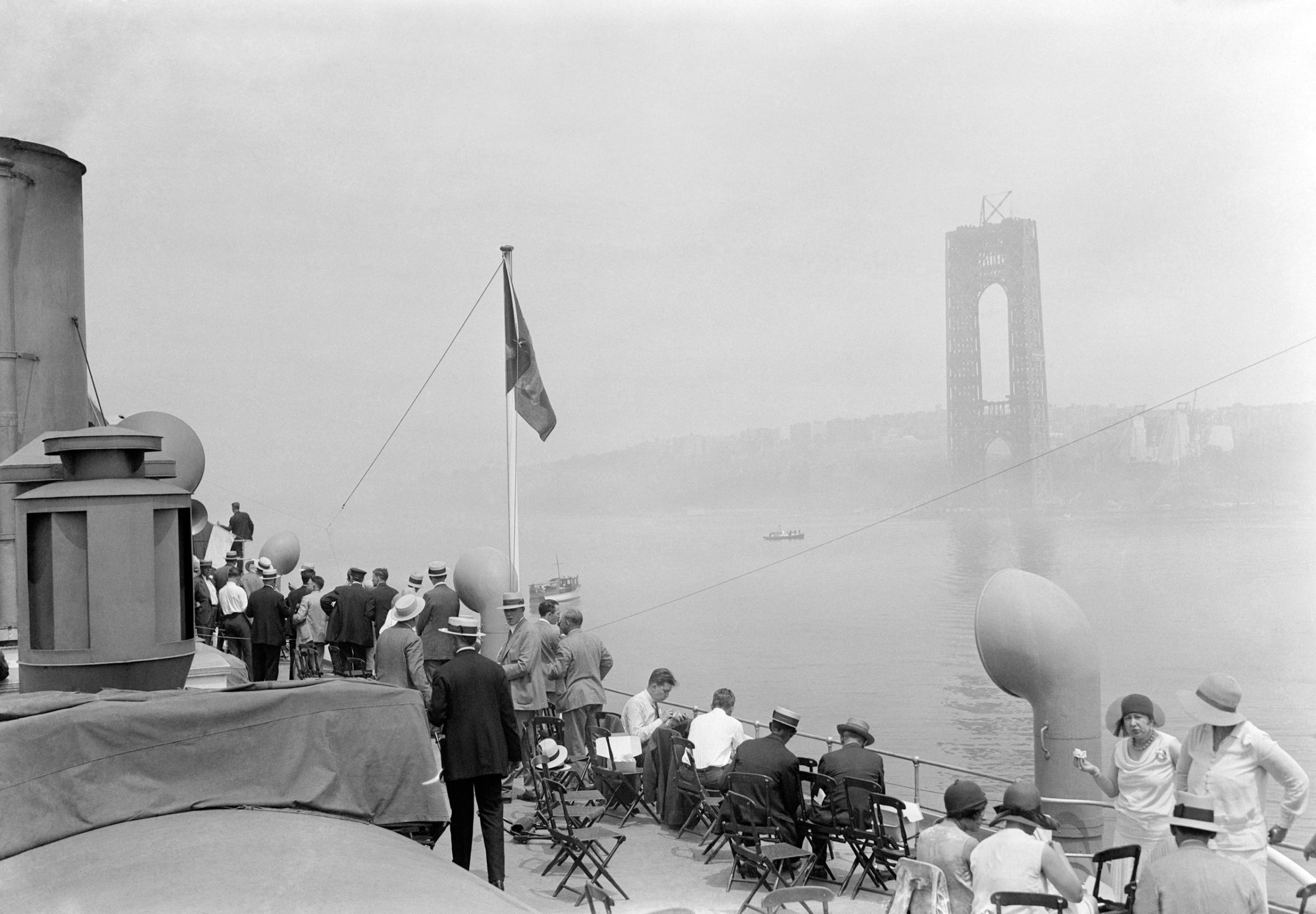 New Jersey and New York connected together by first cable of the new Hudson River Bridge at 178th Street, Manhattan Borough, New York City. Photo shows a general view of the crowd on the Hudson River Day Line steamer Peter Stuyvesant watching the raising of the cable of the new Hudson River Bridge. One of the large piers of the bridge may be seen in the background to where the cable was hoisted from the river bottom.