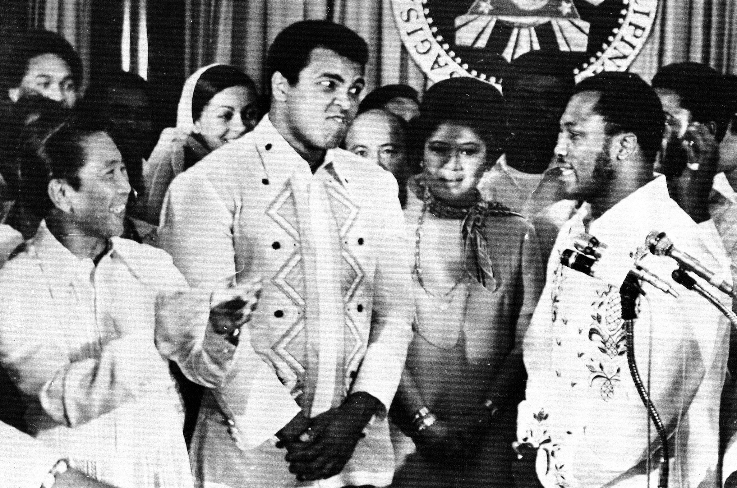 Philippines President Ferdinand Marcos, left, applauds as challenger Joe Frazier, right, makes some remarks about world champion Muhammad Ali, second from left, during their call on Marcos at the Malacanang Palace in Manila, Philippines, on Sept. 18, 1975. Between the two fighters is Marco's wife Imelda.