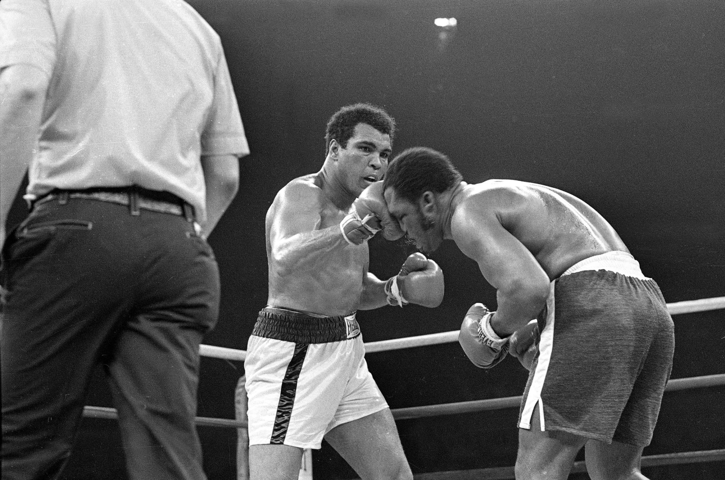 Muhammad Ali connects with the top of Joe Frazier's head in the 13th round of their bout for the heavyweight title at Araneta Coliseum in Quezon, the Philippines, October 1, 1975.