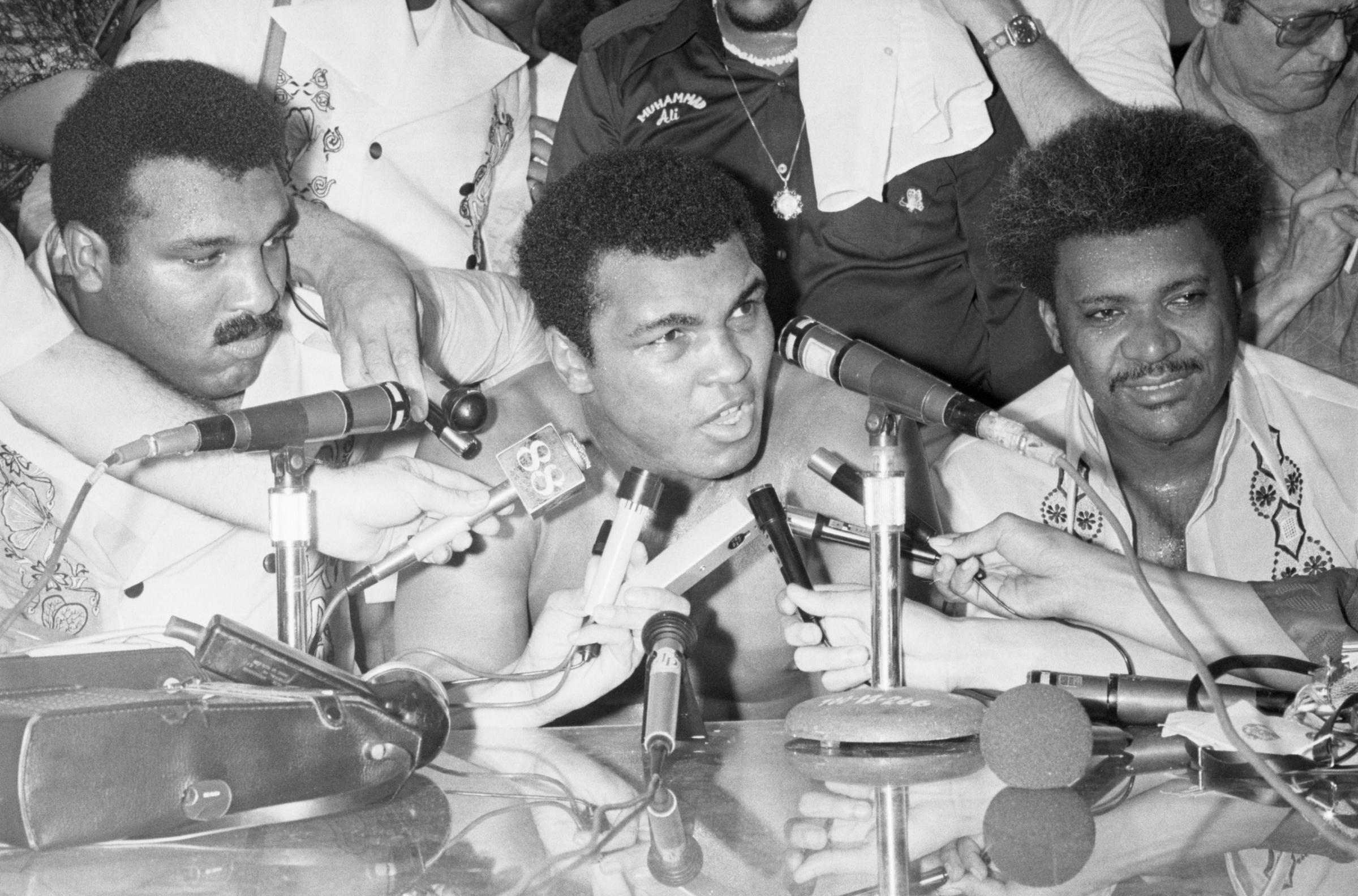 Heavyweight champion of the world Muhammad Ali (C) meets with the press after defeating challenger Smokin' Joe Frazier in the 14th round by TKO. Next to Ali is boxing promoter Don King (R), and Ali's brother Rahaman. Manila, Luzon Island, Philippines, October 1, 1975.