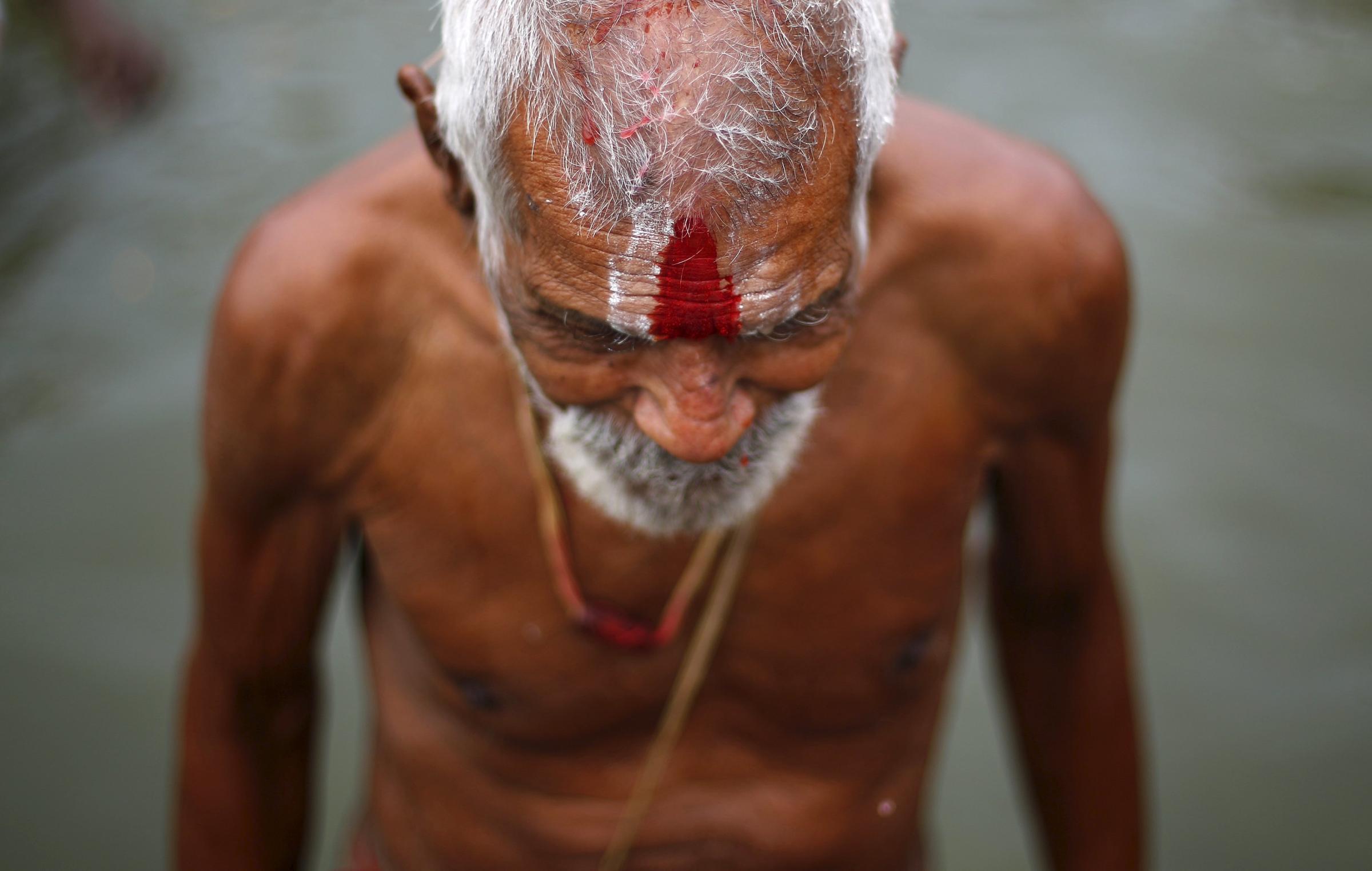 A sadhu or a Hindu holy man comes out of the waters of Godavari river after taking a dip during the Kumbh Mela in Nashik