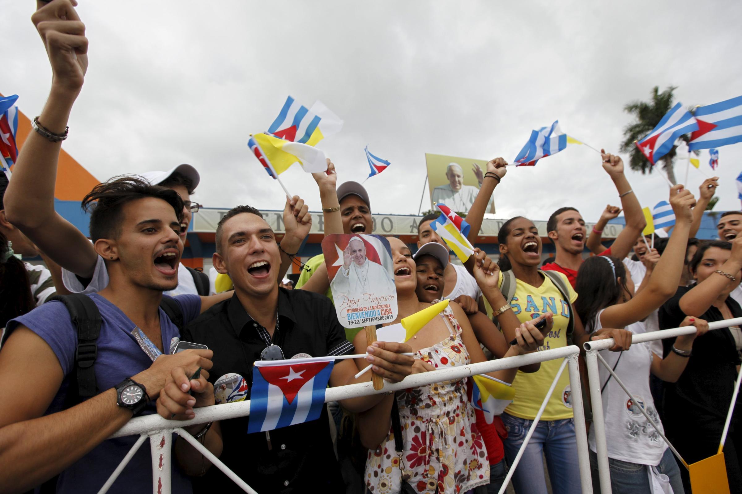 People react after the arrival of Pope Francis outside the airport in Havana