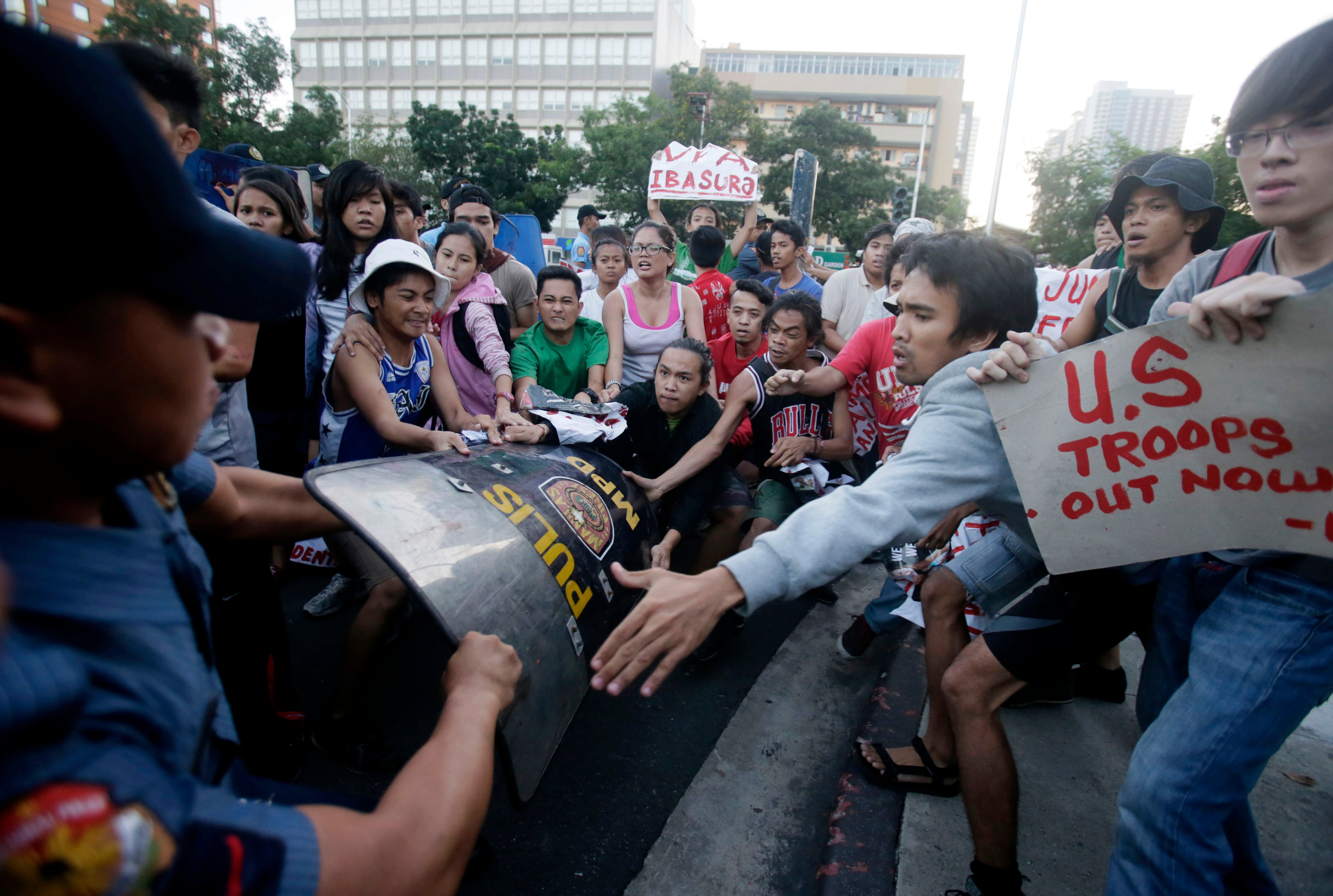 Protesters grab the riot shield of a police officer as the former managed to slip past them for a rally to mark the 24th year anniversary of the termination of the U.S. military bases in the country Wednesday, Sept. 16, 2015 at the U.S. Embassy in Manila, Philippines. (Bullit Marquez&mdash;AP)