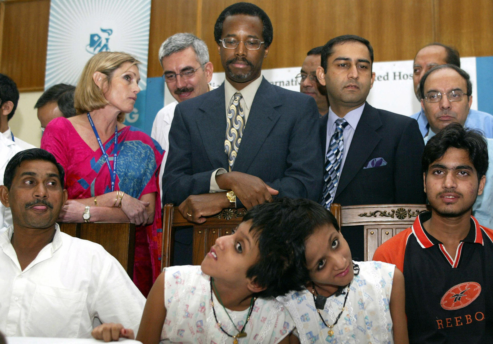 Ten-year-old Indian twins Sabah and Farah sit beside Ben Carson (C), Managing Director, Apollo Hospital, New Delhi, Anne Marie Moncure, their father Shakeel (L), their brother (R) and senior child specialist of Apollo Hospital, Dr. Anupan Sibal, on Oct. 4, 2005  in New Delhi.