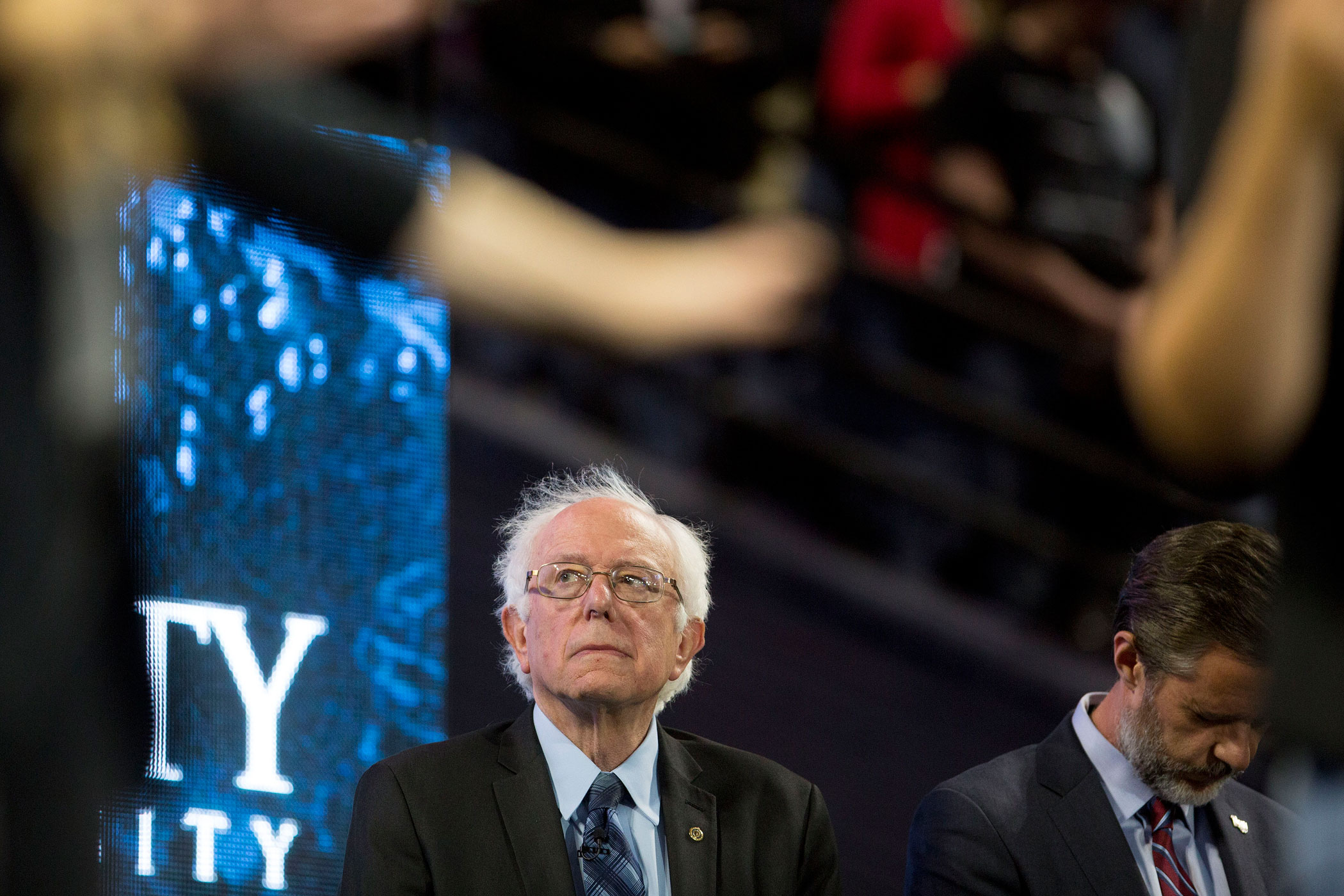 Senator Bernie Sanders, an independent from Vermont and 2016 Democratic presidential candidate, left, and Jerry Falwell Jr., president of Liberty University, listen to a prayer during a Liberty University Convocation in Lynchburg, Virginia, U.S., on Monday, Sept. 14, 2015. Sanders now leads his Democratic rival former secretary of state Hillary Clinton by double digits in Iowa and New Hampshire, the first two states in where votes will be cast in 2016 to decide the party's presidential nominee. Photographer: Andrew Harrer/Bloomberg via Getty Images
